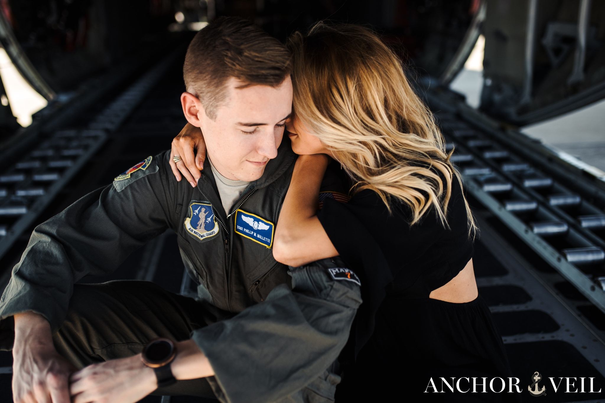 whispering in his ear during the aviation themed engagement session in Charlotte NC