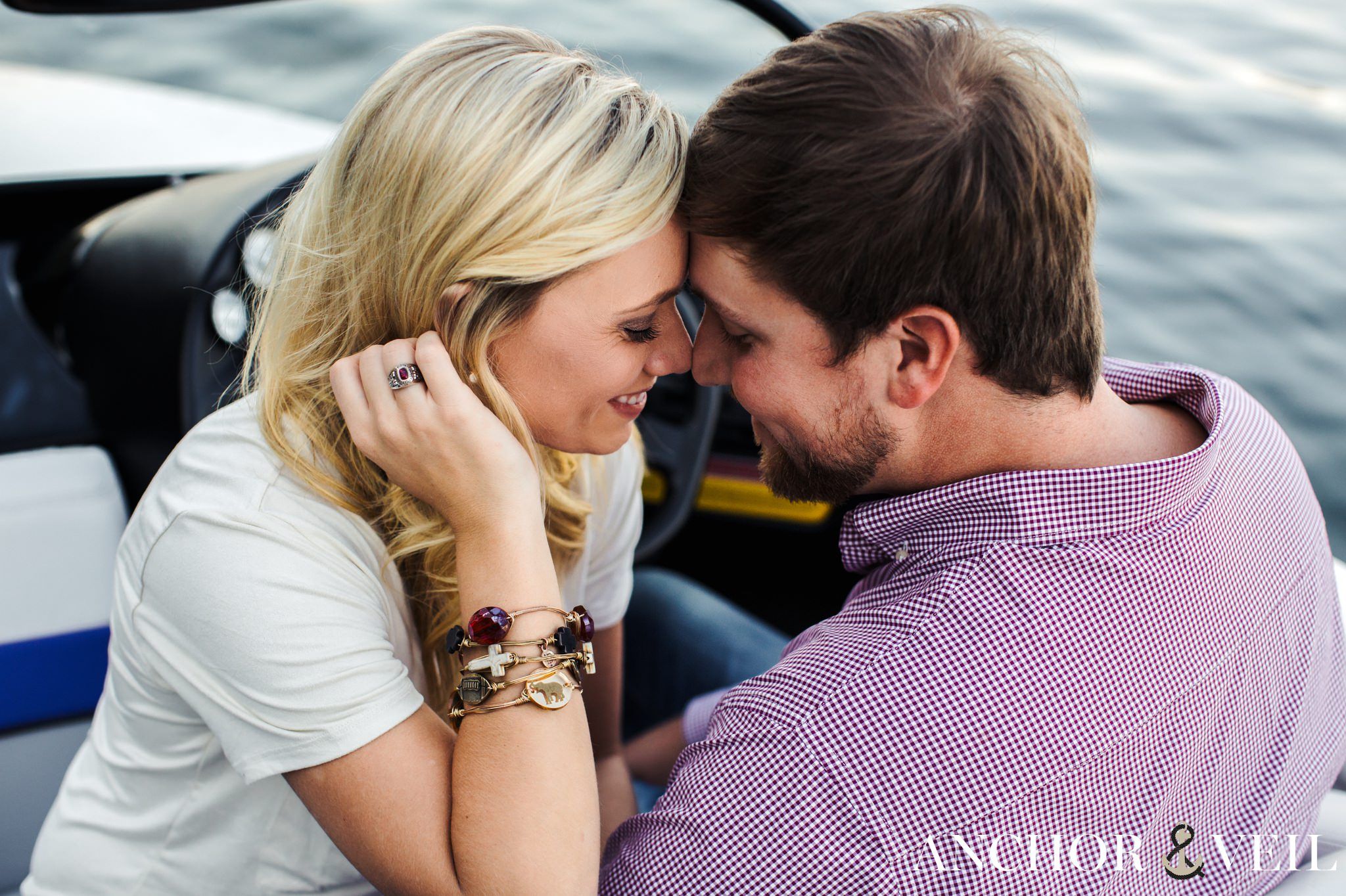 foreheads together on the boat during the belews lake engagement session
