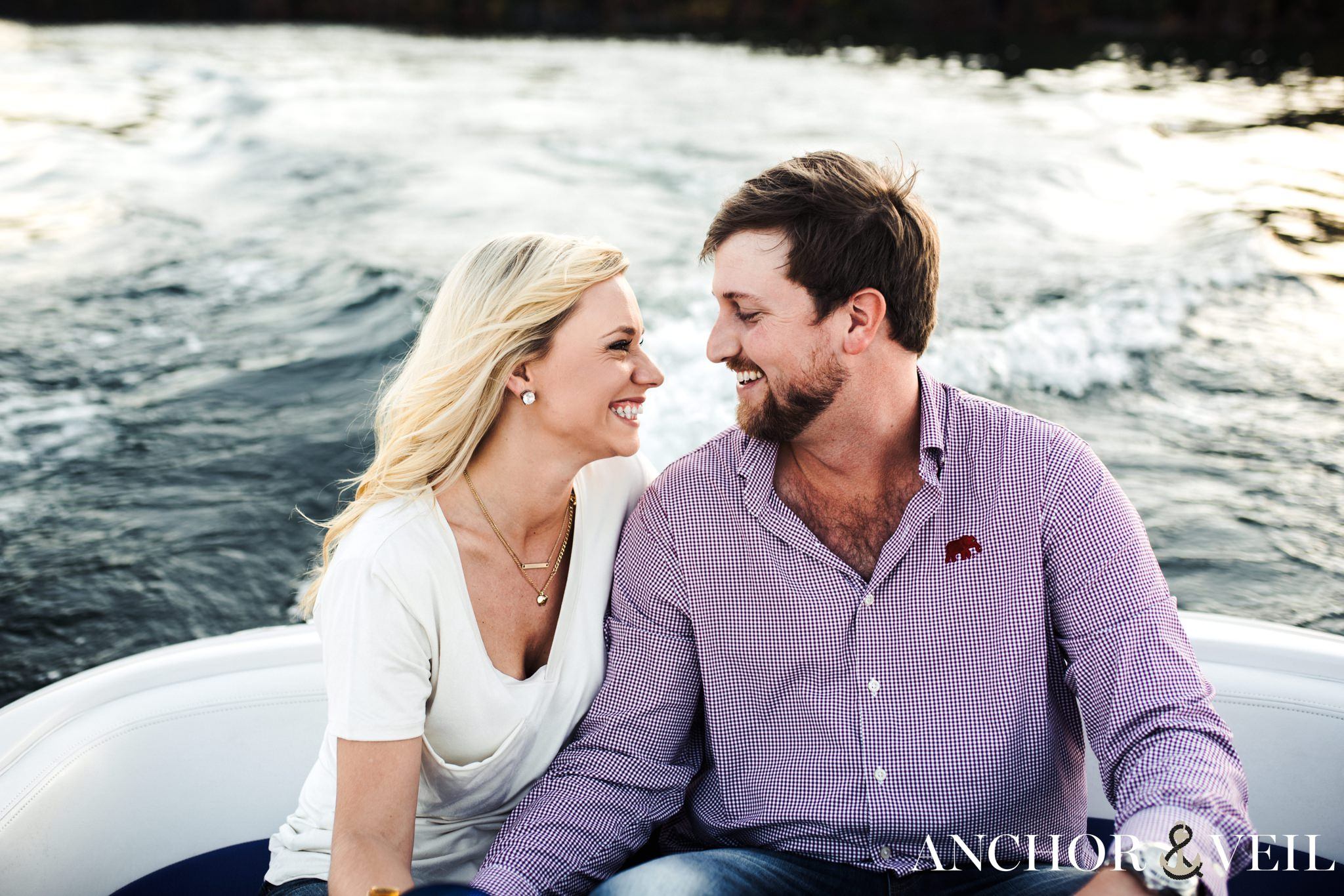 driving the boat as they laugh during the belews lake engagement session