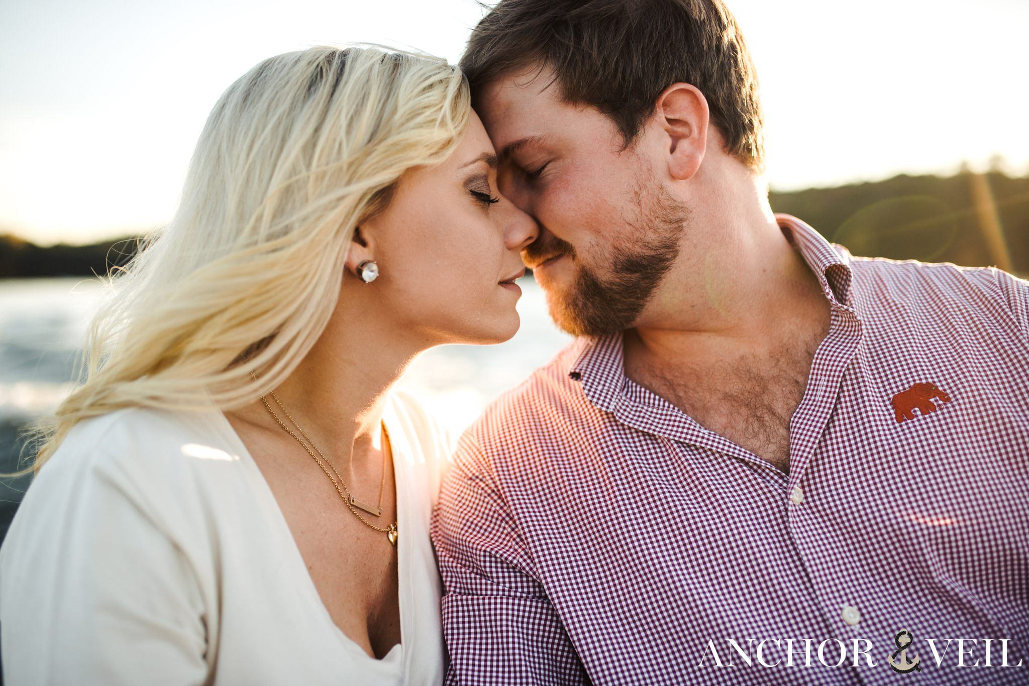 almost kissing in the light on the boat during the belews lake engagement session