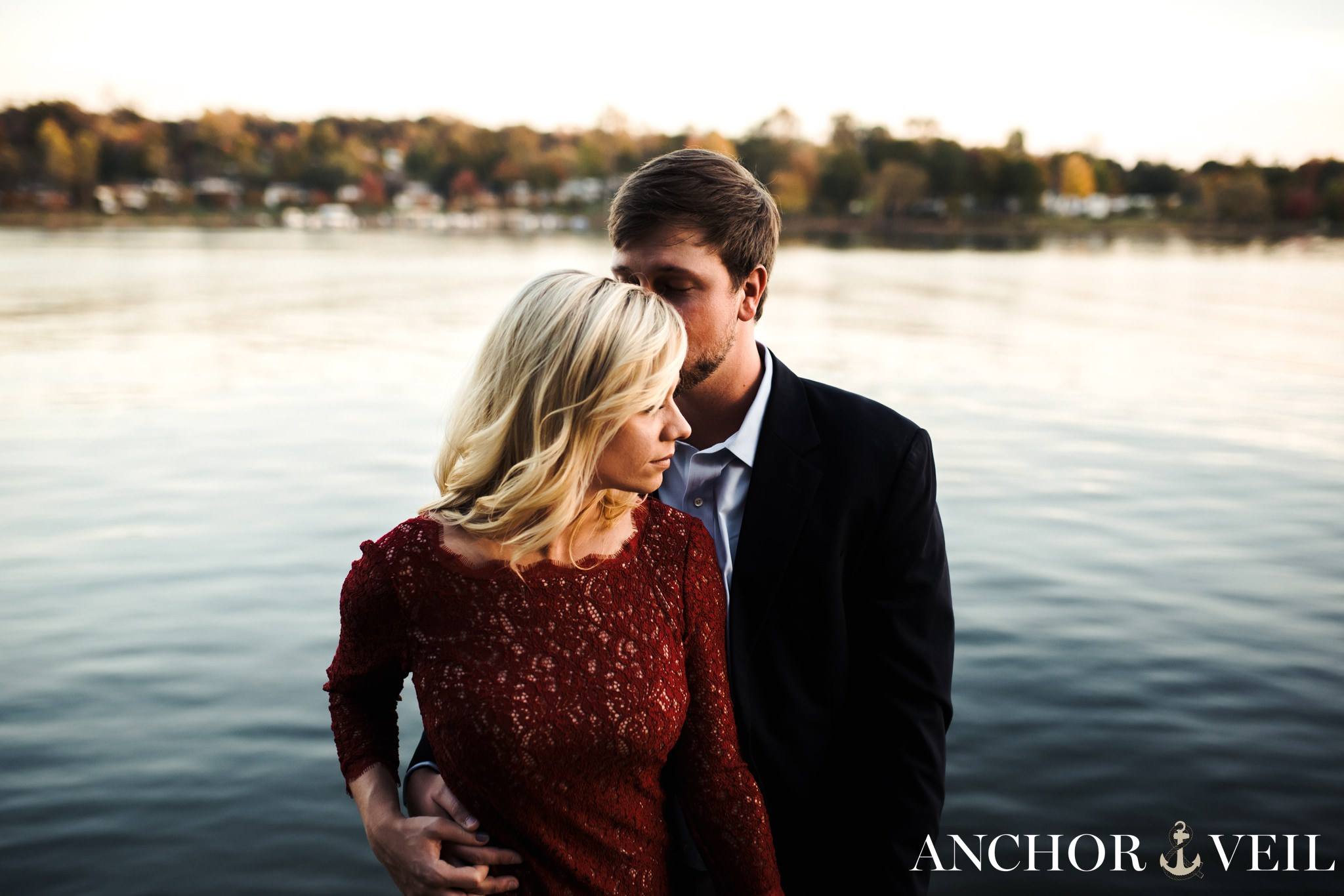 holding her from behind on the lake during the belews lake engagement session
