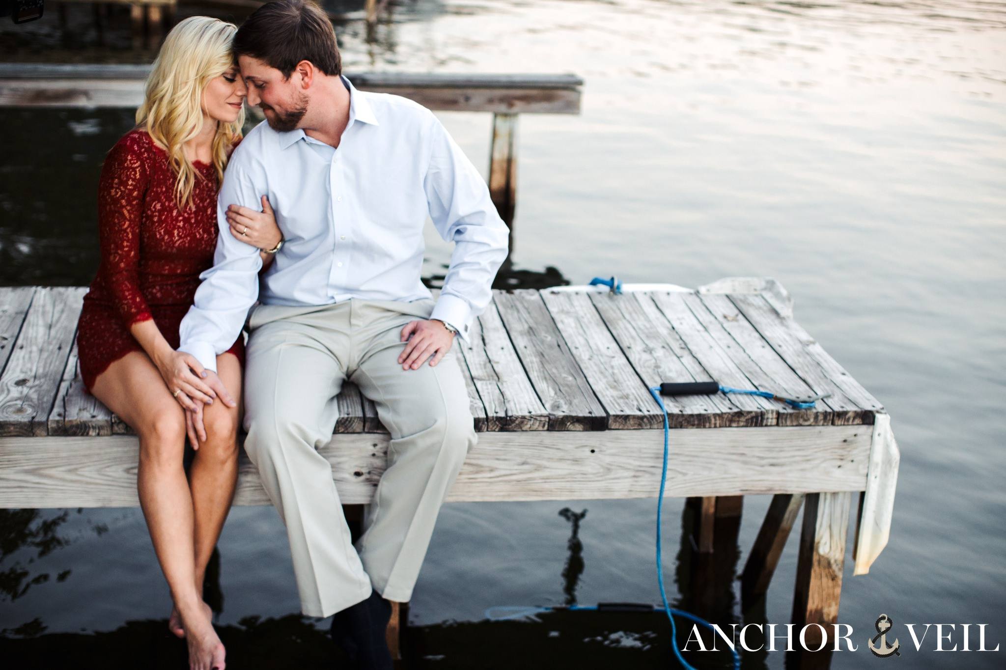 sitting on the dock almost kissing during the belews lake engagement session
