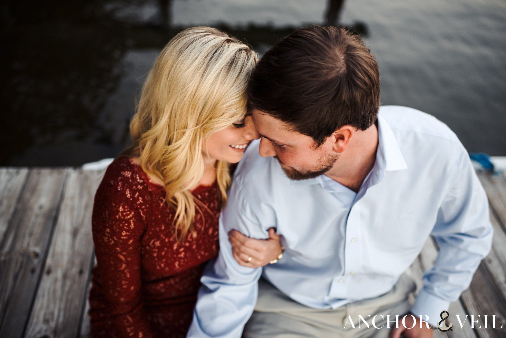 foreheads together on the dock during the belews lake engagement session
