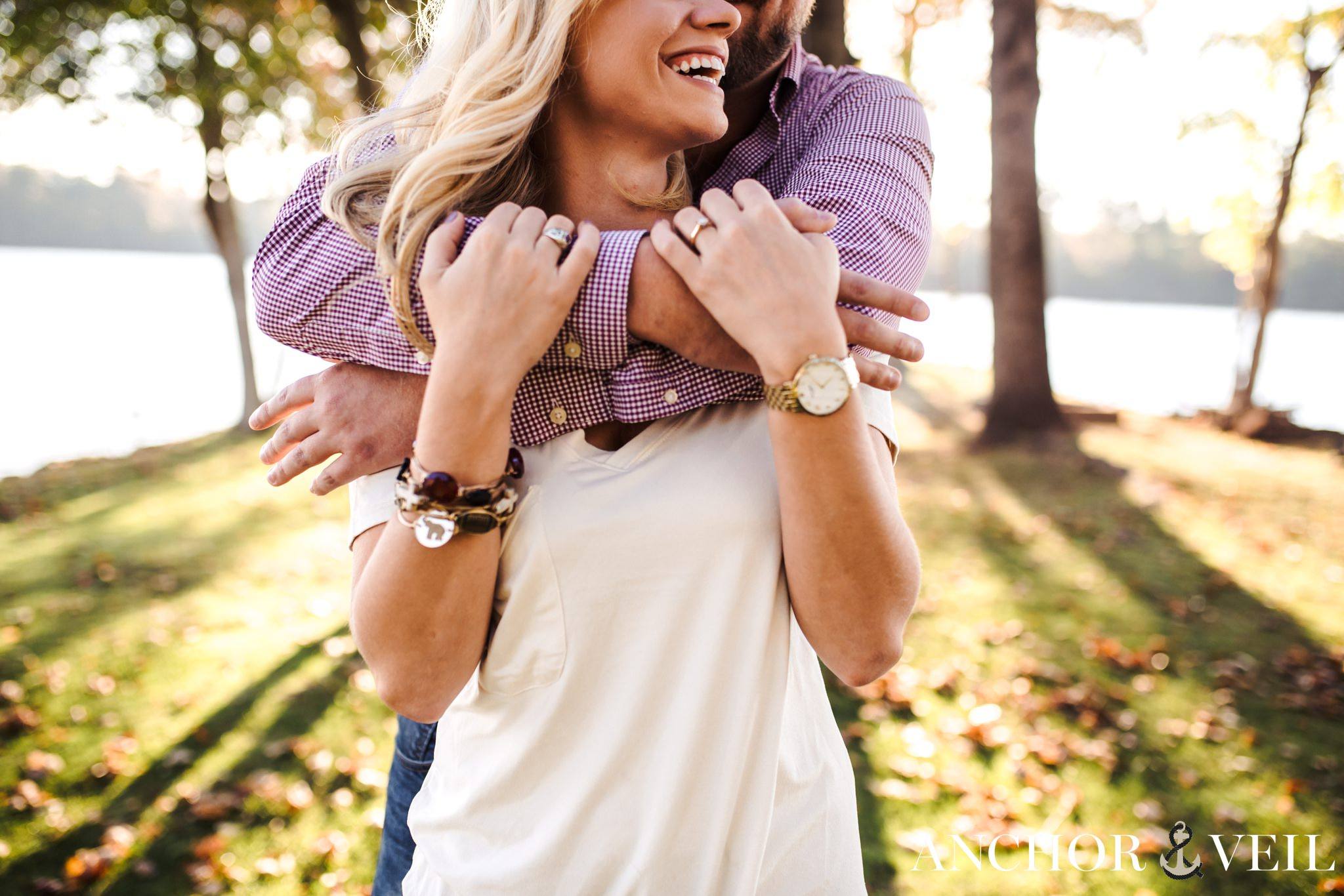 holding him tight as he hlder her during the belews lake engagement session