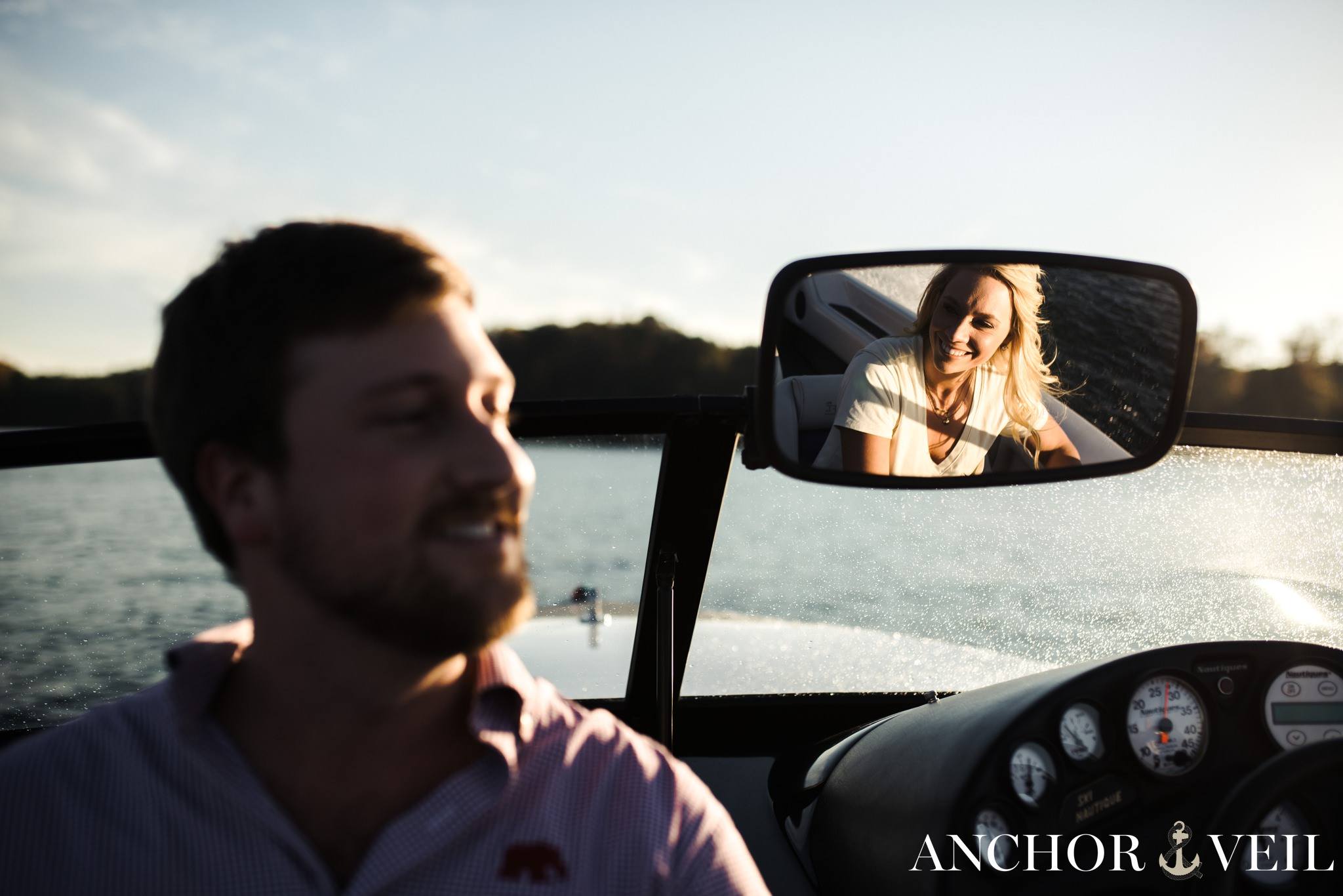driving the boat and see her face through the mirror during the belews lake engagement session