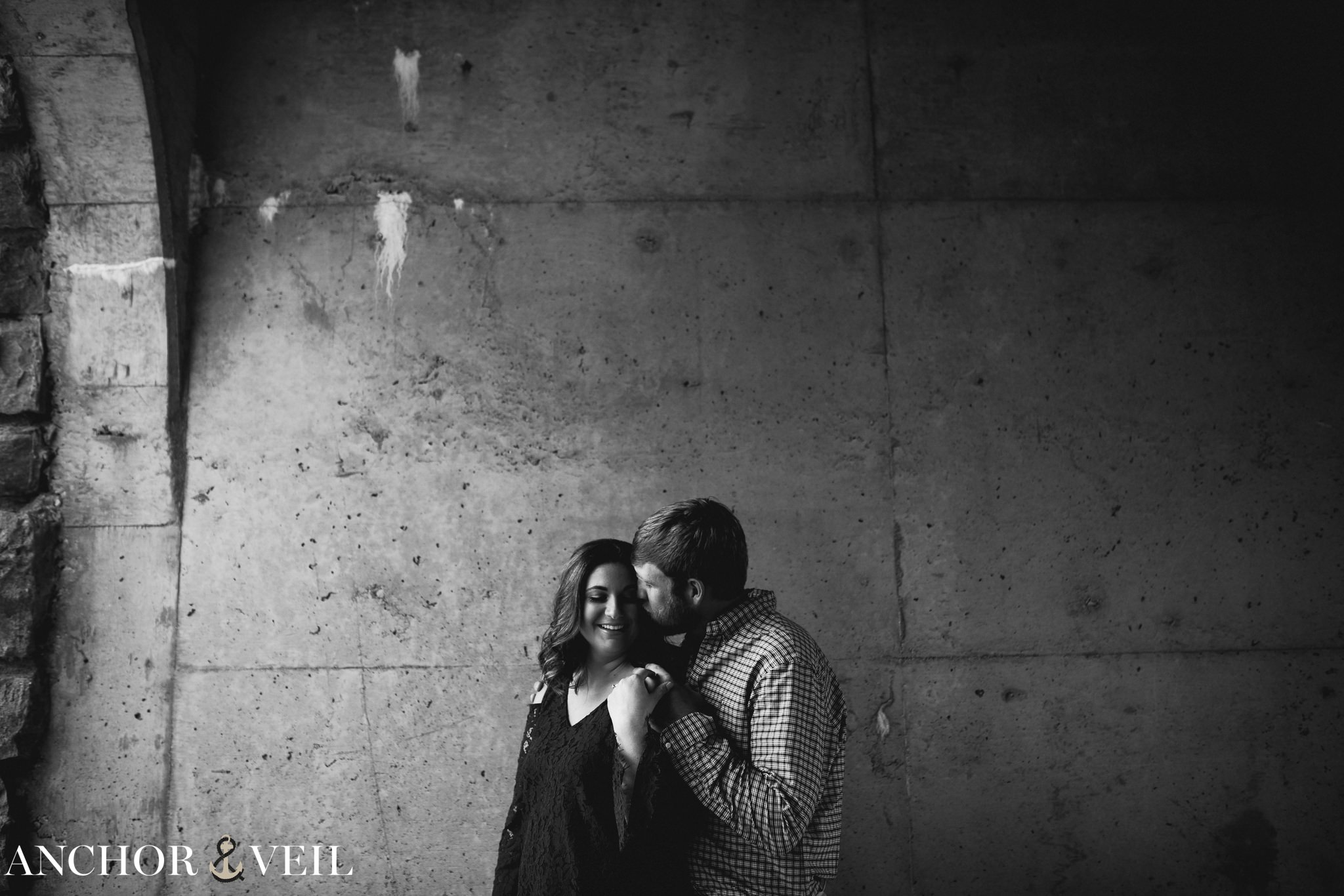 holding her while they stand against the wall during the Blue Ridge Mountains Engagement Session