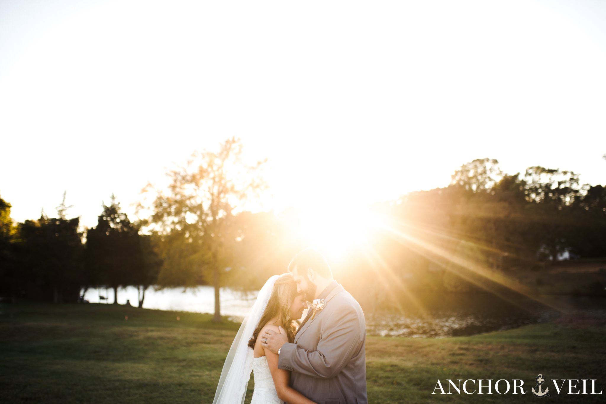 bride and groom kissing in the sun