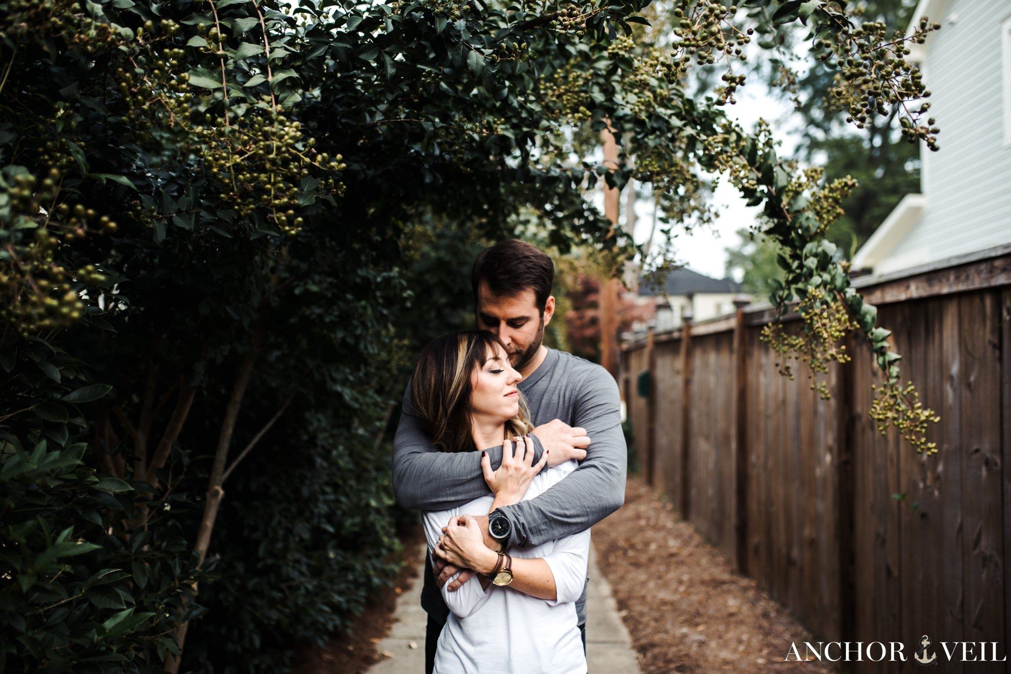 holding her tight around the neck during the Uptown Charlotte Engagement Session
