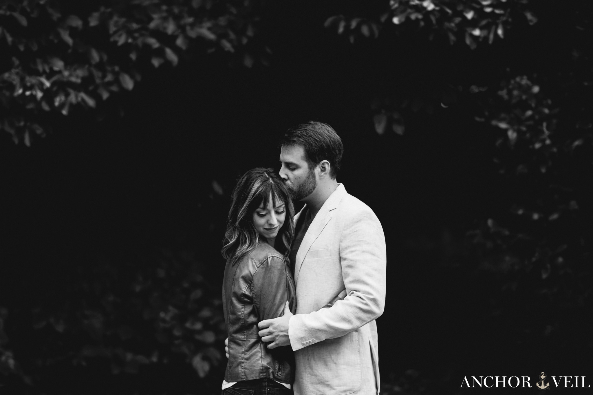 holding tight with black and white backgorund during the Uptown Charlotte Engagement Session