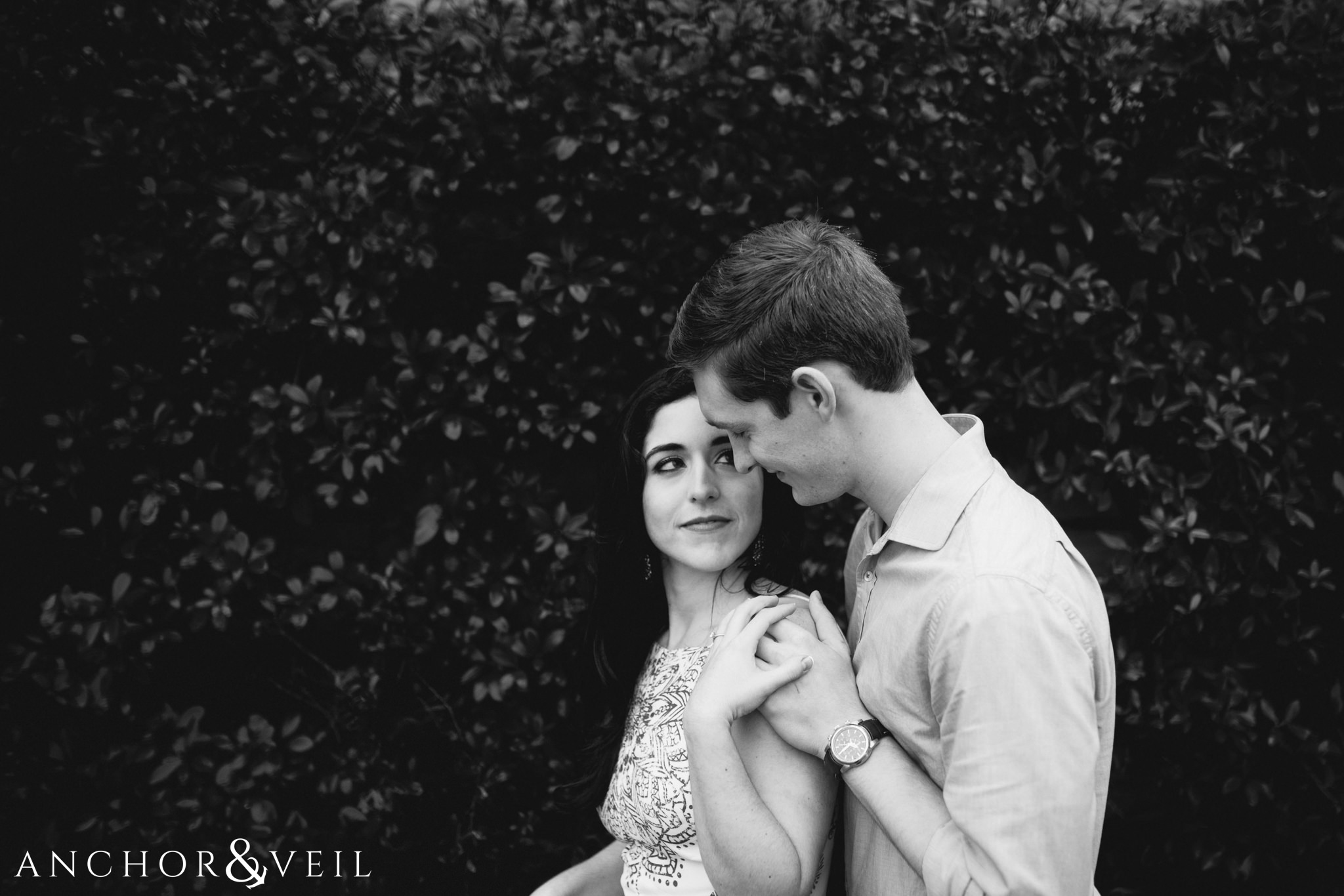 holding her tight in the bushes during their folly beach and legare waring house engagement session