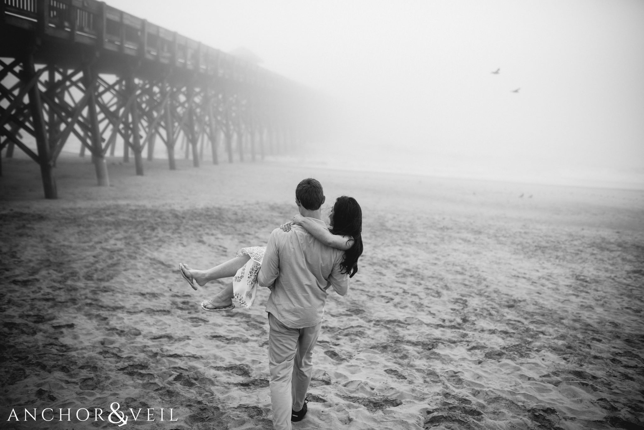 taking a walk on the beach during their folly beach and legare waring house engagement session