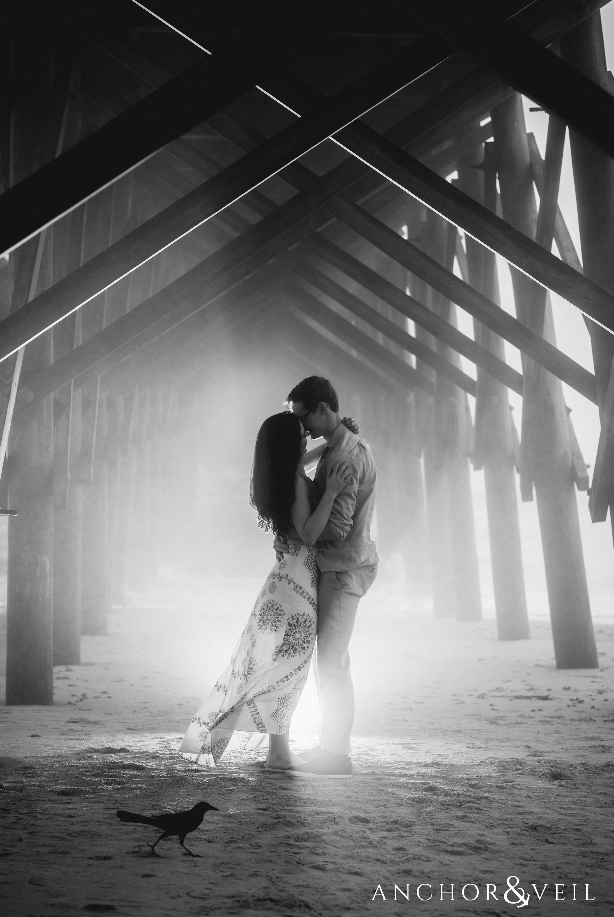 awesome light under the pier during their folly beach and legare waring house engagement session
