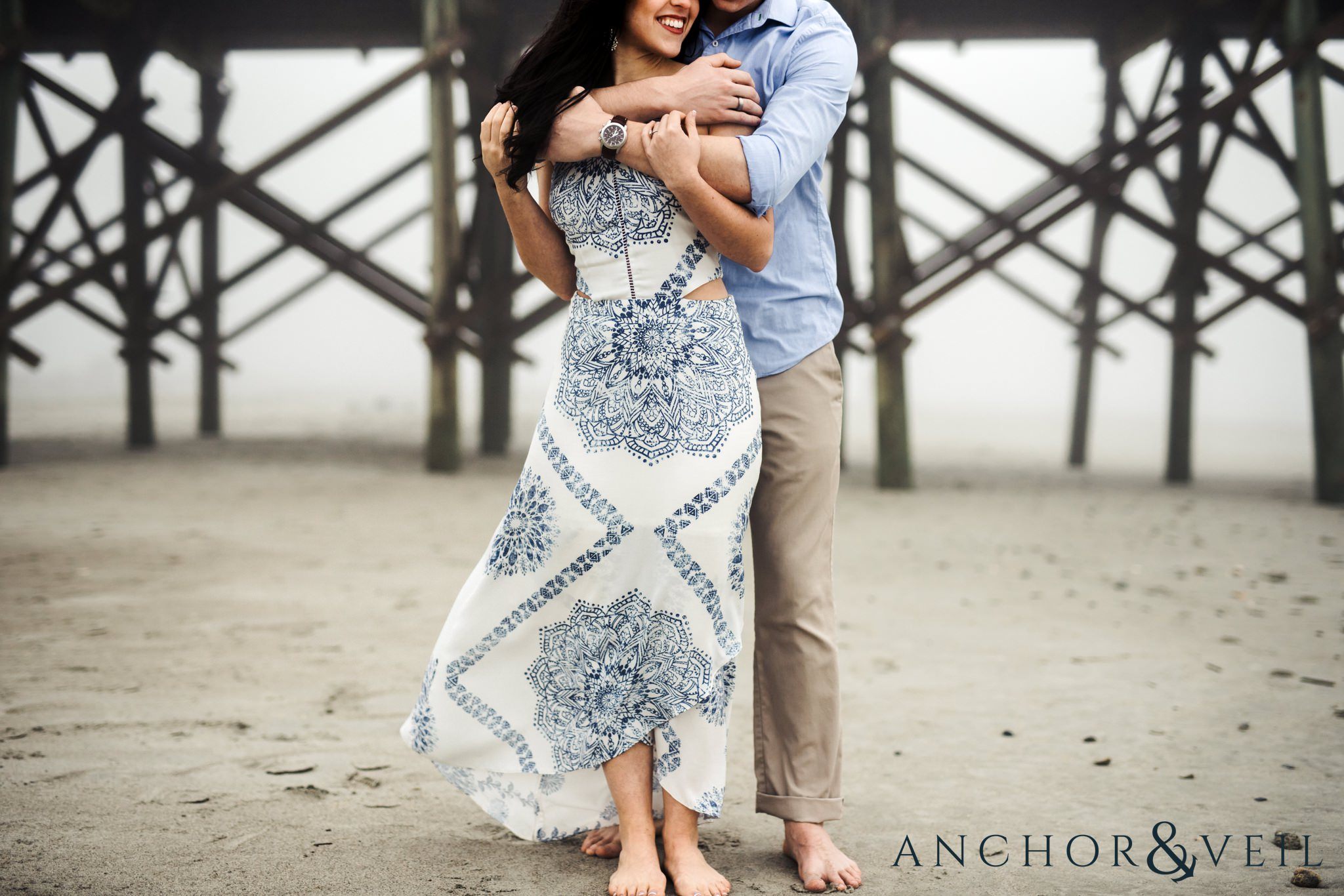 holding each other near the pier during their folly beach and legare waring house engagement session