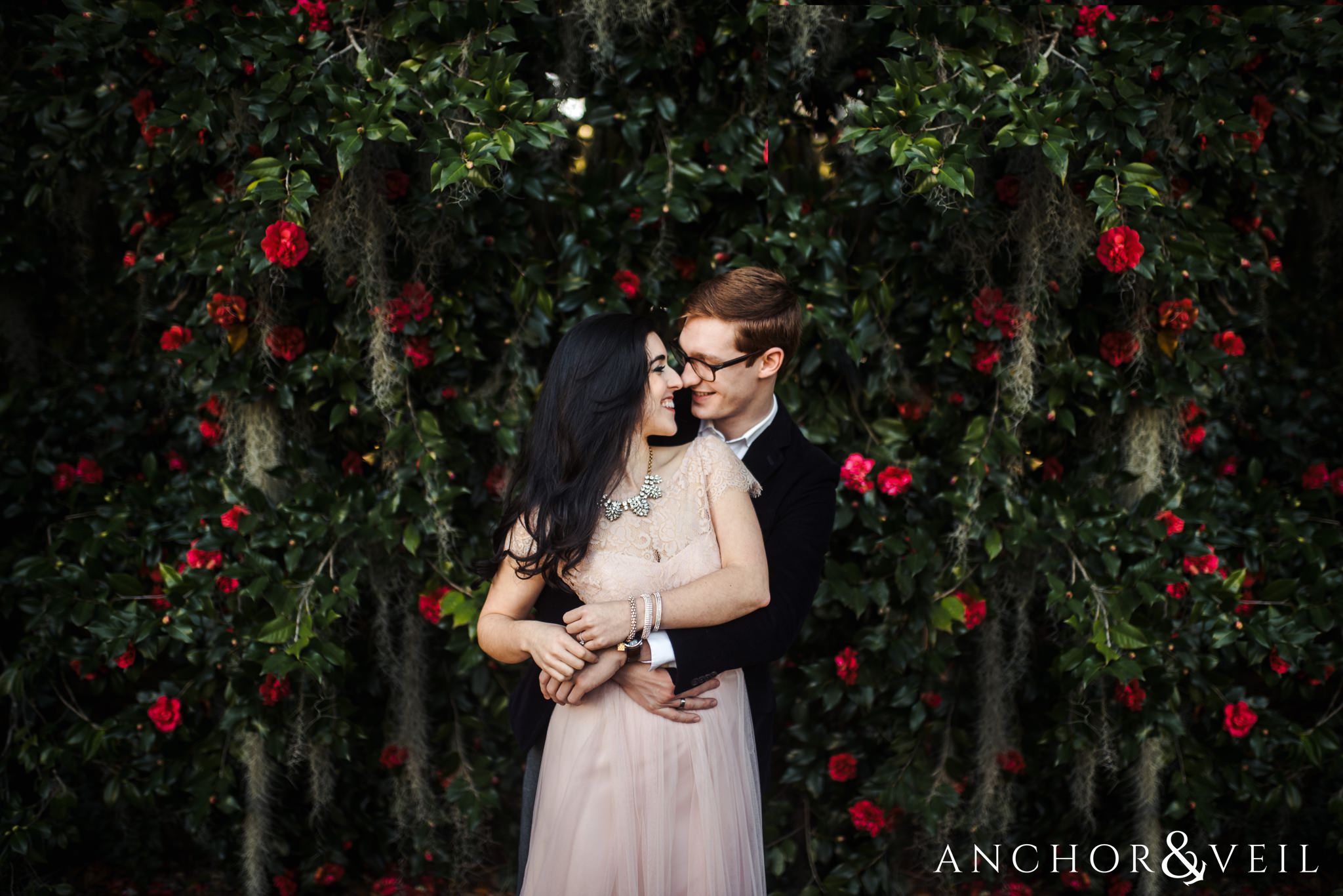 red flowers and moss during their legare waring house engagement session