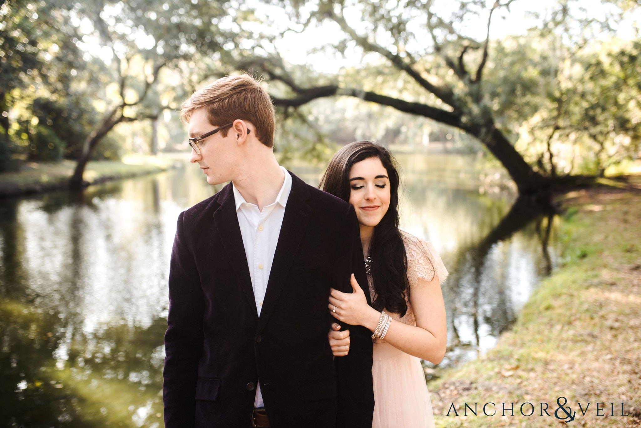 standing in front of the water during their legare waring house engagement session