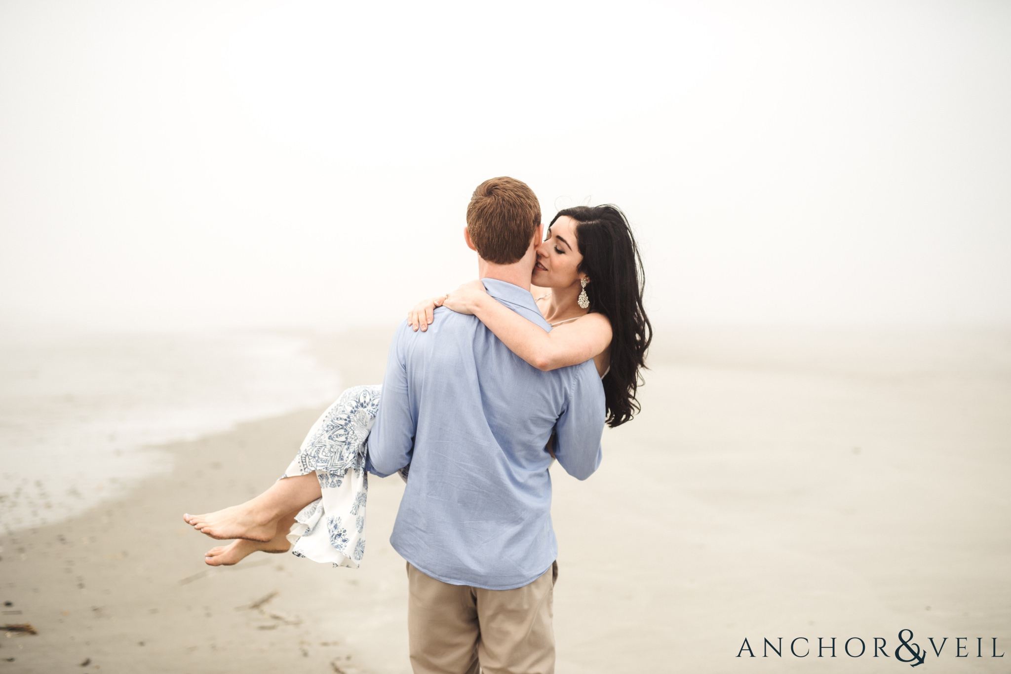walking with her and holding during their folly beach and legare waring house engagement session