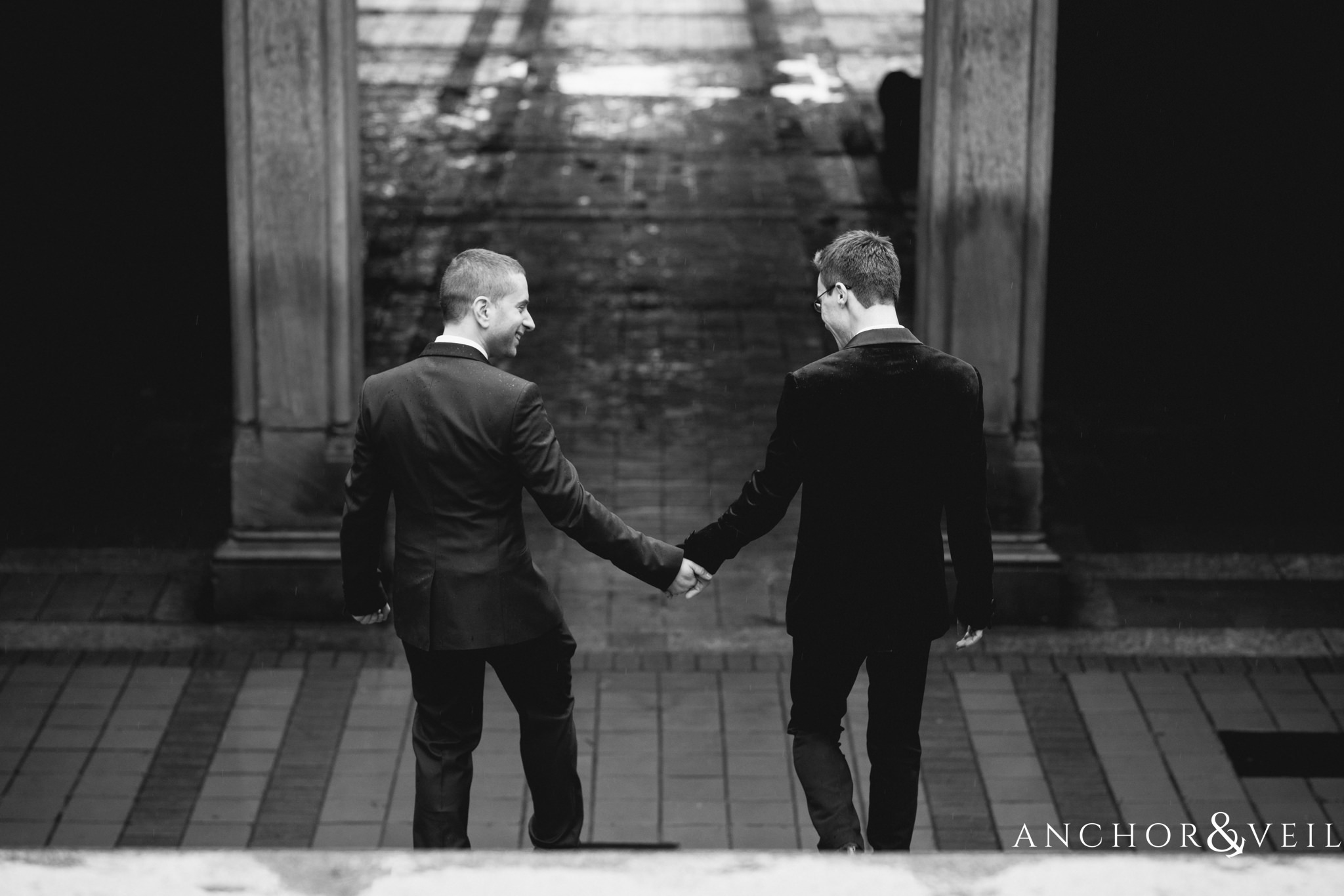 holding hands walking down the stairs during their central park elopement in bethesda Terrace