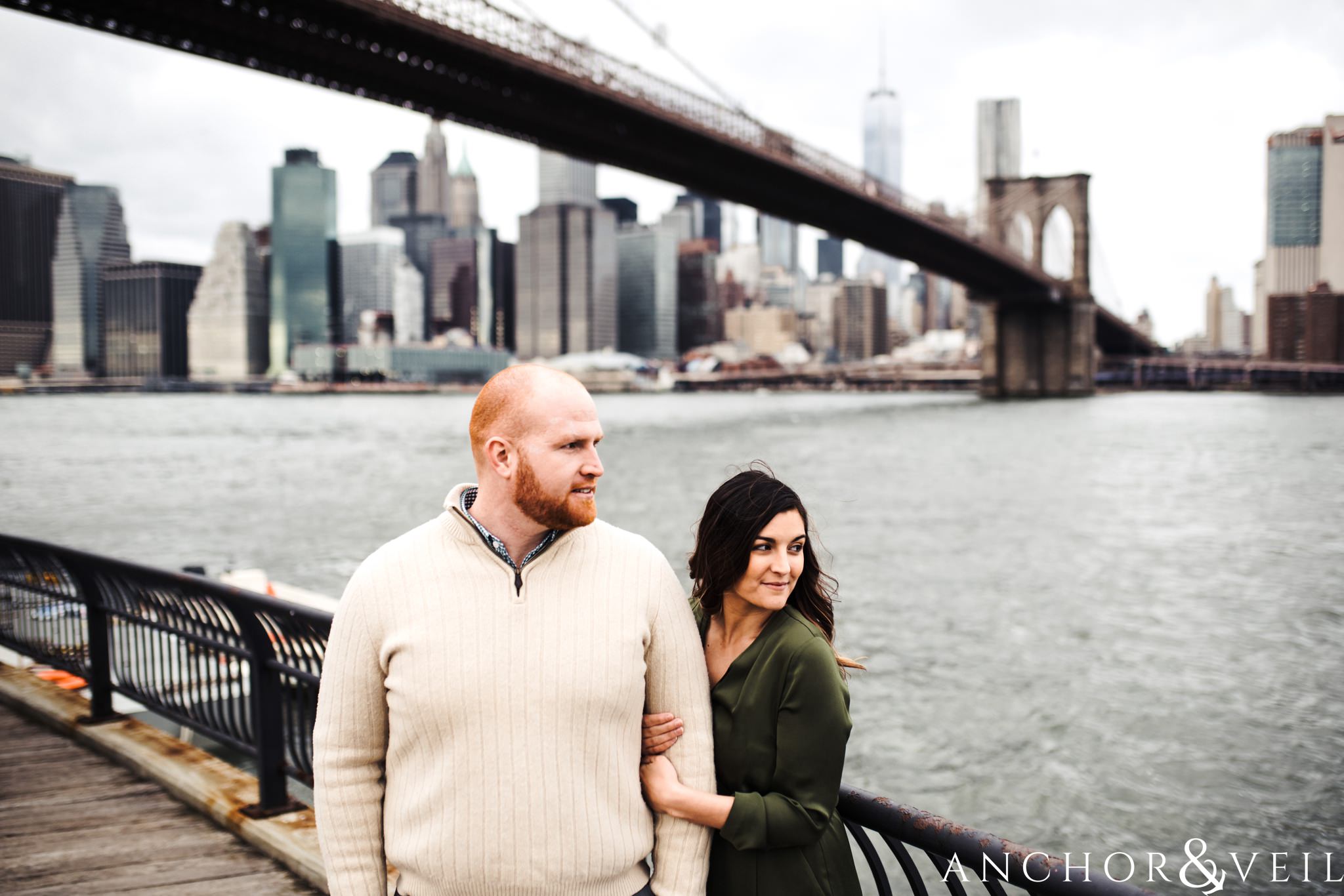 under the bridge with the manhattan skyline During their Dumbo Brooklyn New York engagement session