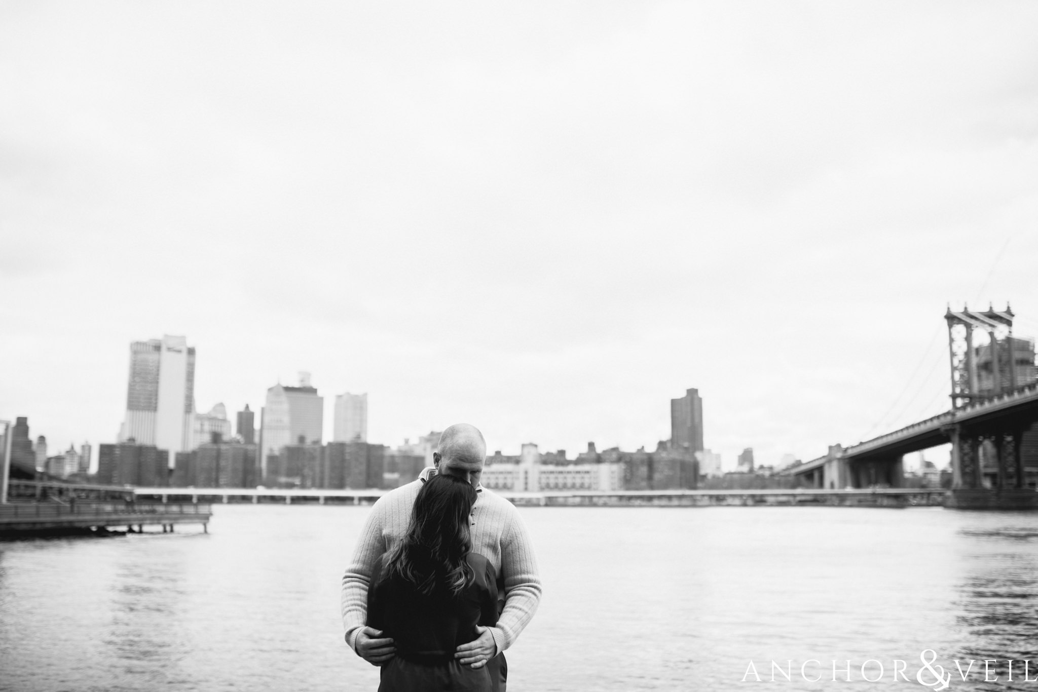 standing against the hudson river During their Dumbo Brooklyn New York engagement session