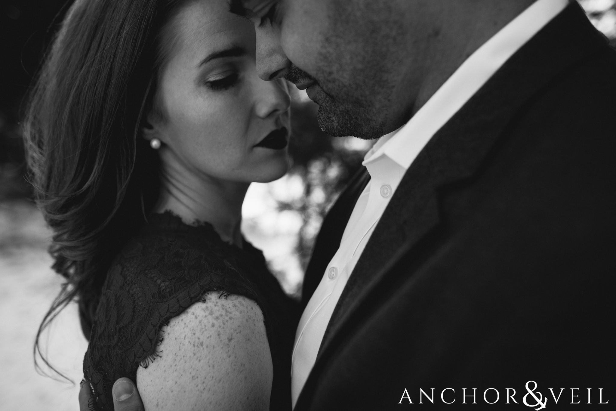 getting in close in blacka nd white during their Charlotte Snow engagement session in the woods