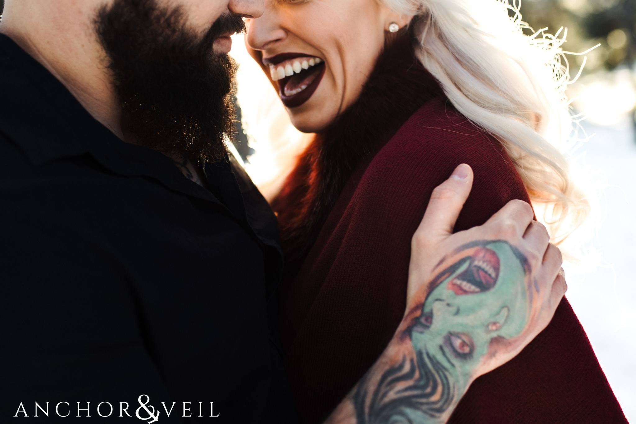 laughing with the laughing tattoo during their charlotte snow engagement session