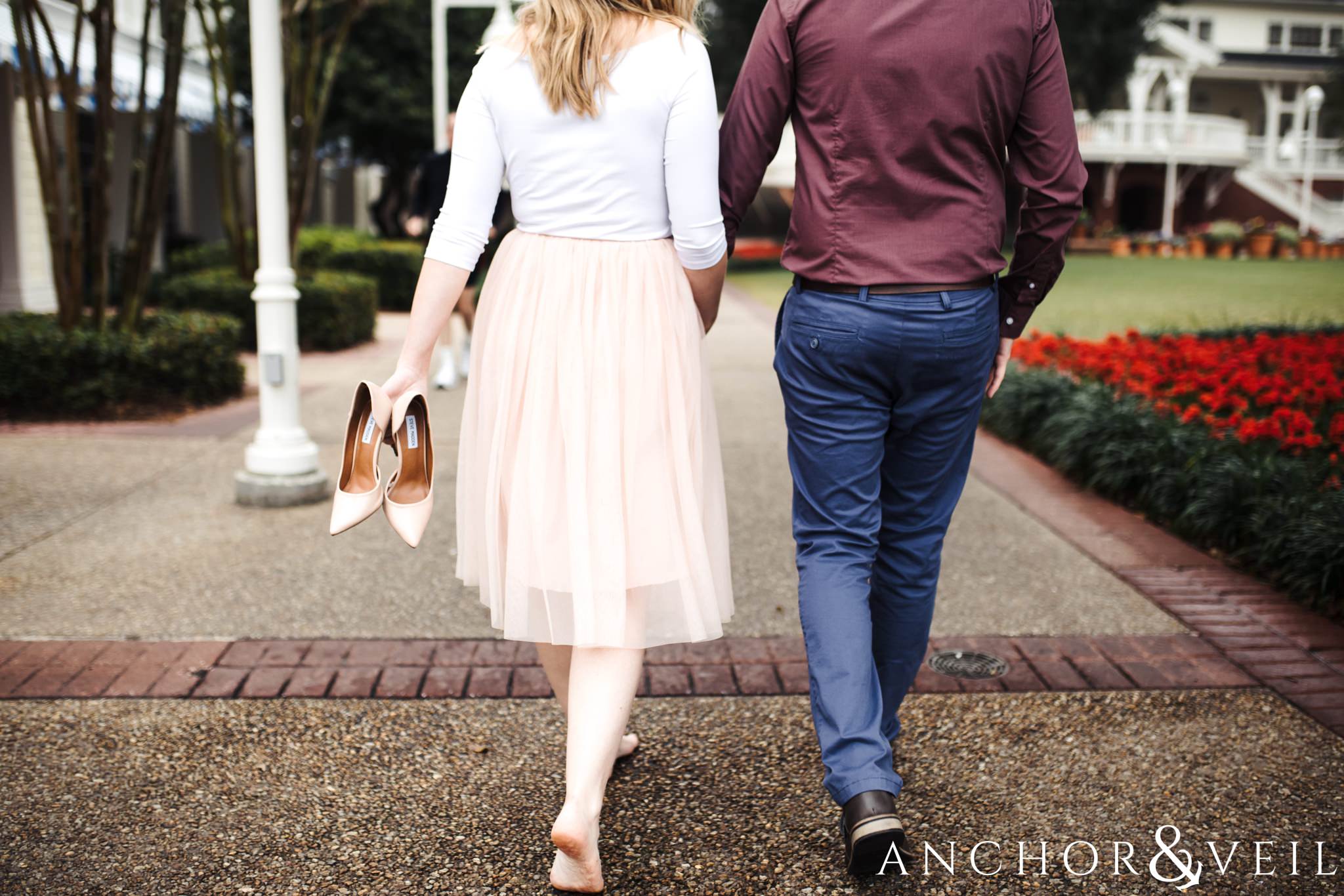 walking hand in hand during their Disney world engagement session at the Boardwalk Hotel Inn
