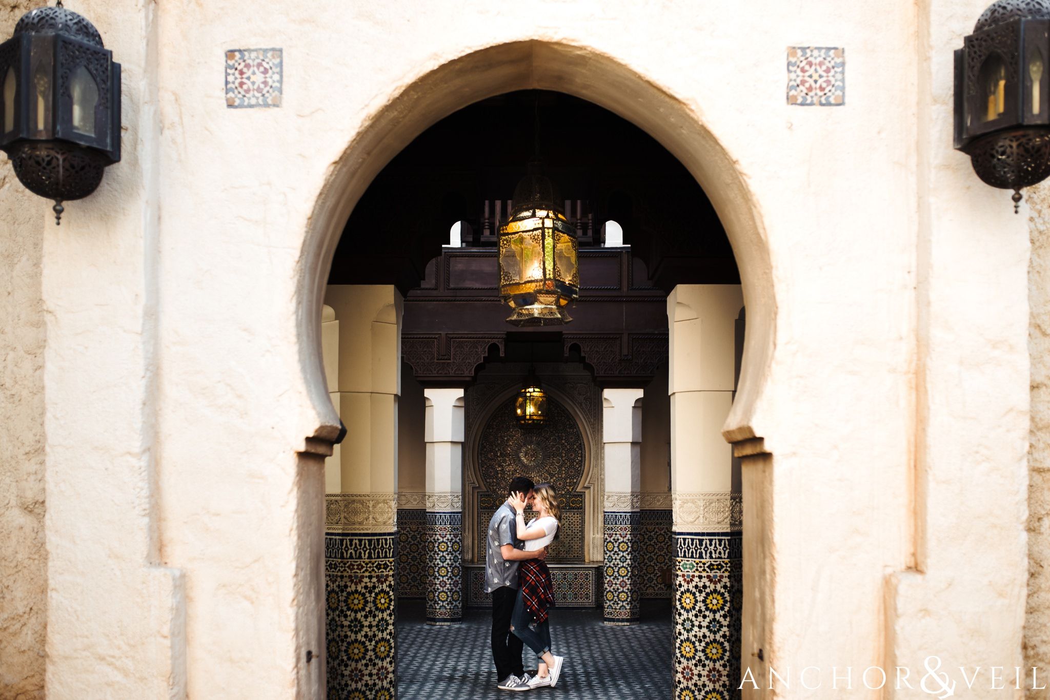 arches and kissing in morocco during their Disney world engagement session at Disney's Epcot