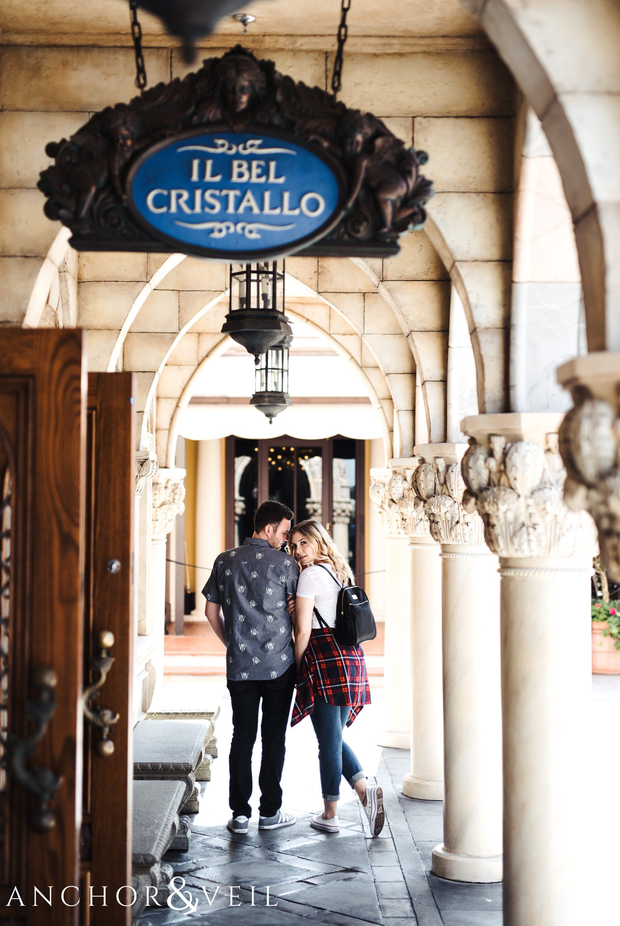 Kissing under the arches in italy during their Disney world engagement session at Disney's Epcot
