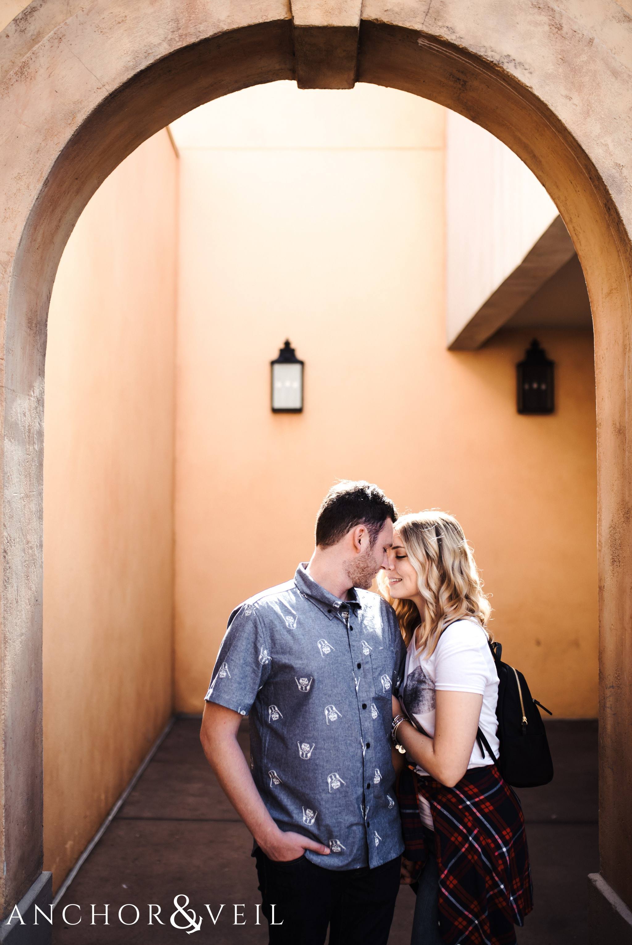 looking at him in the orange arches in italy during their Disney world engagement session at Disney's Epcot
