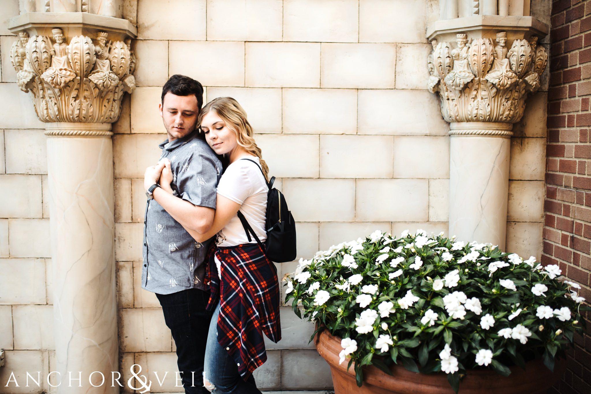 leaning on him in the stone arches in italy during their Disney world engagement session at Disney's Epcot