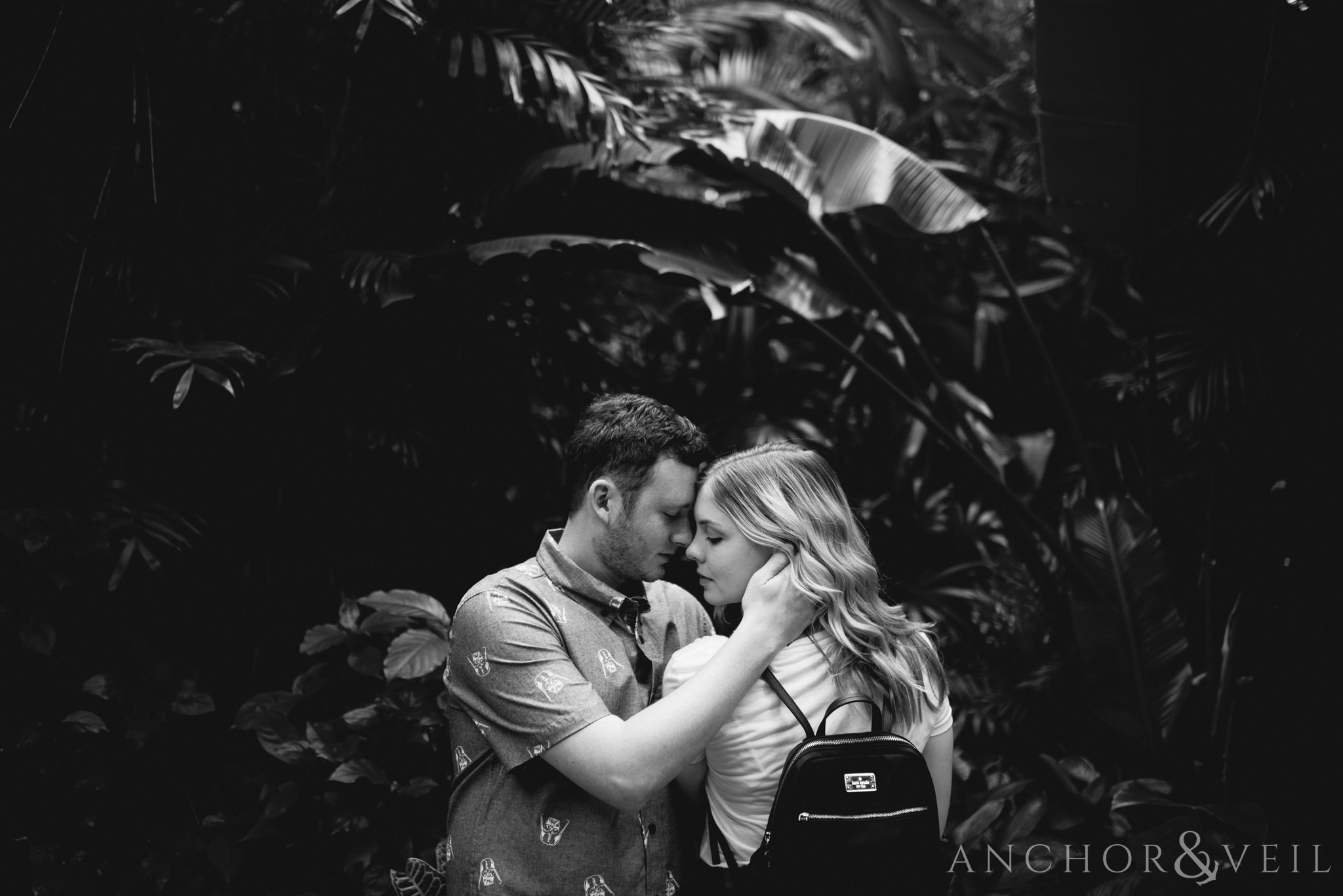 looking at each other in the jungle of mexico during their Disney world engagement session at Disney's Epcot