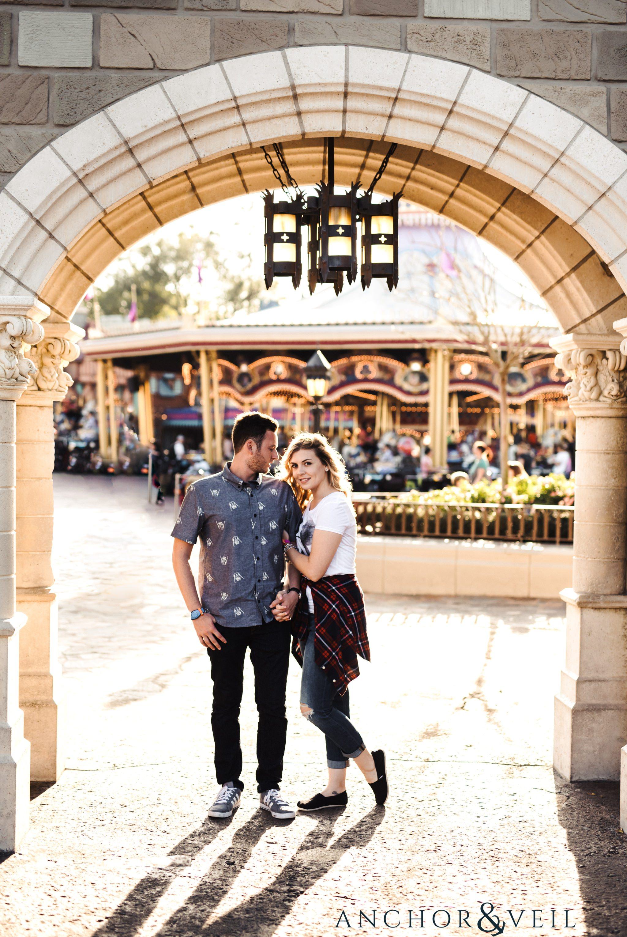 in the arches during their Disney world engagement session at Disney's Magic Kingdom