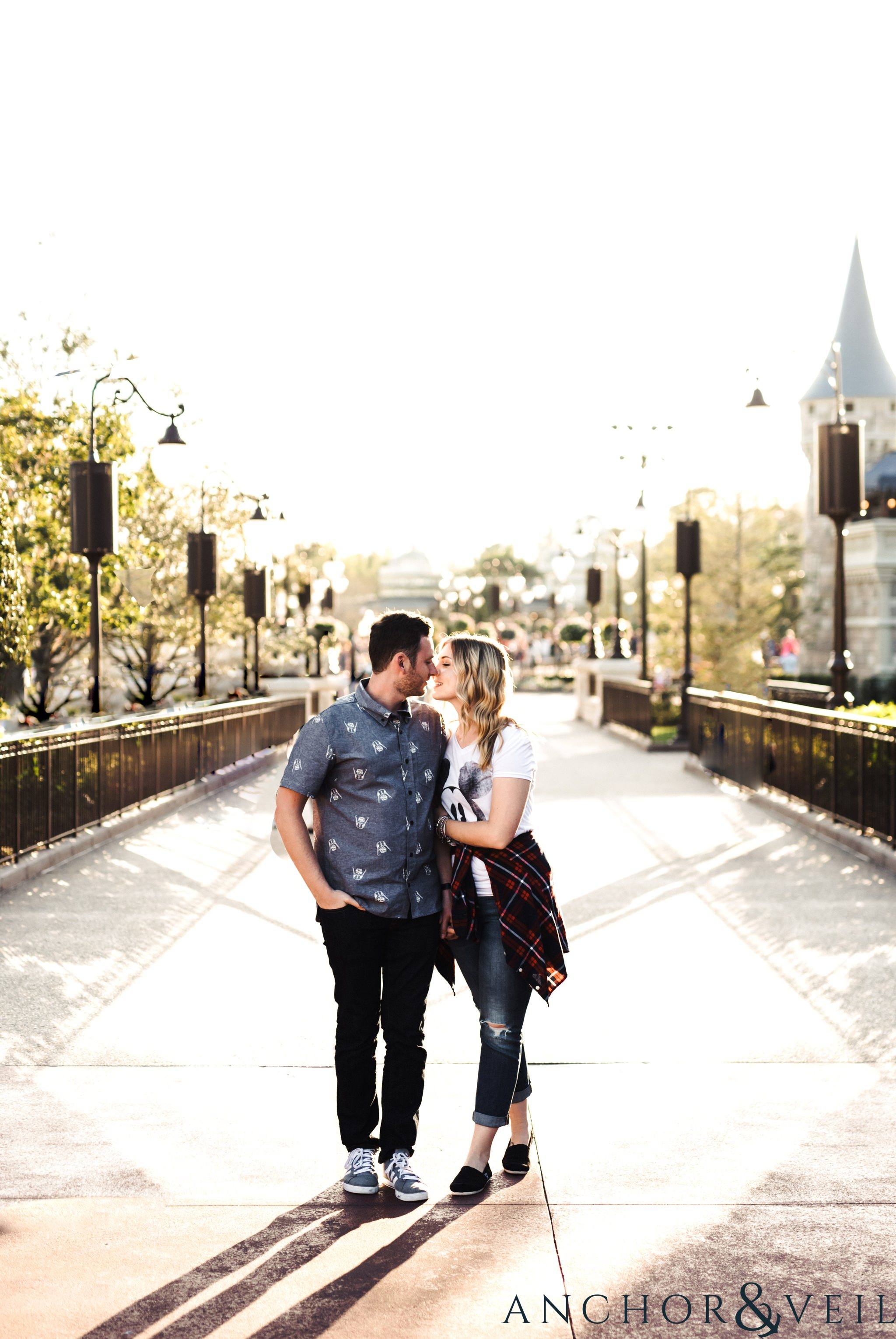 almost kissing on the bridge during their Disney world engagement session at Disney's Magic Kingdom