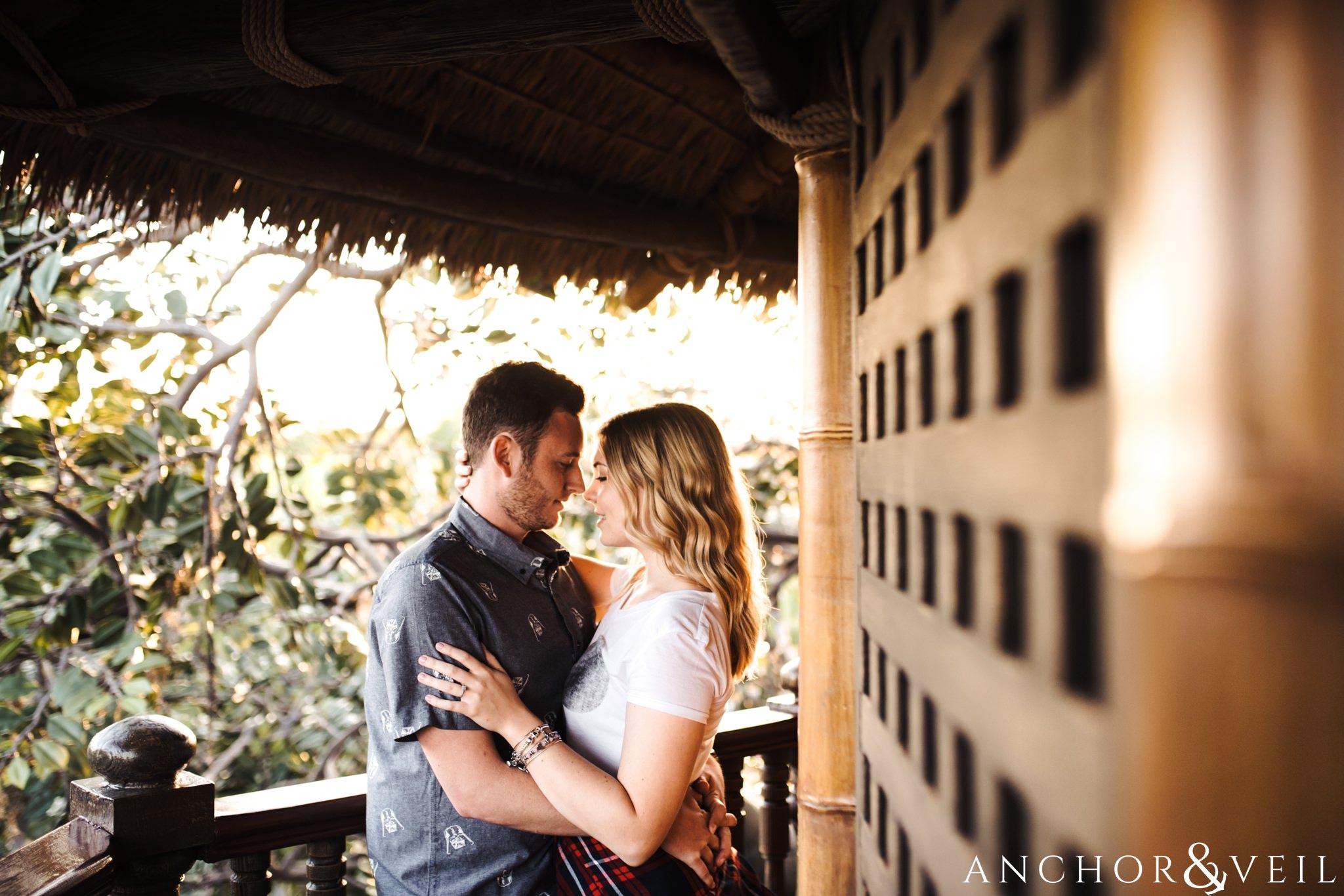 getting close in the robinson crusoe tree house during their Disney world engagement session at Disney's Magic Kingdom