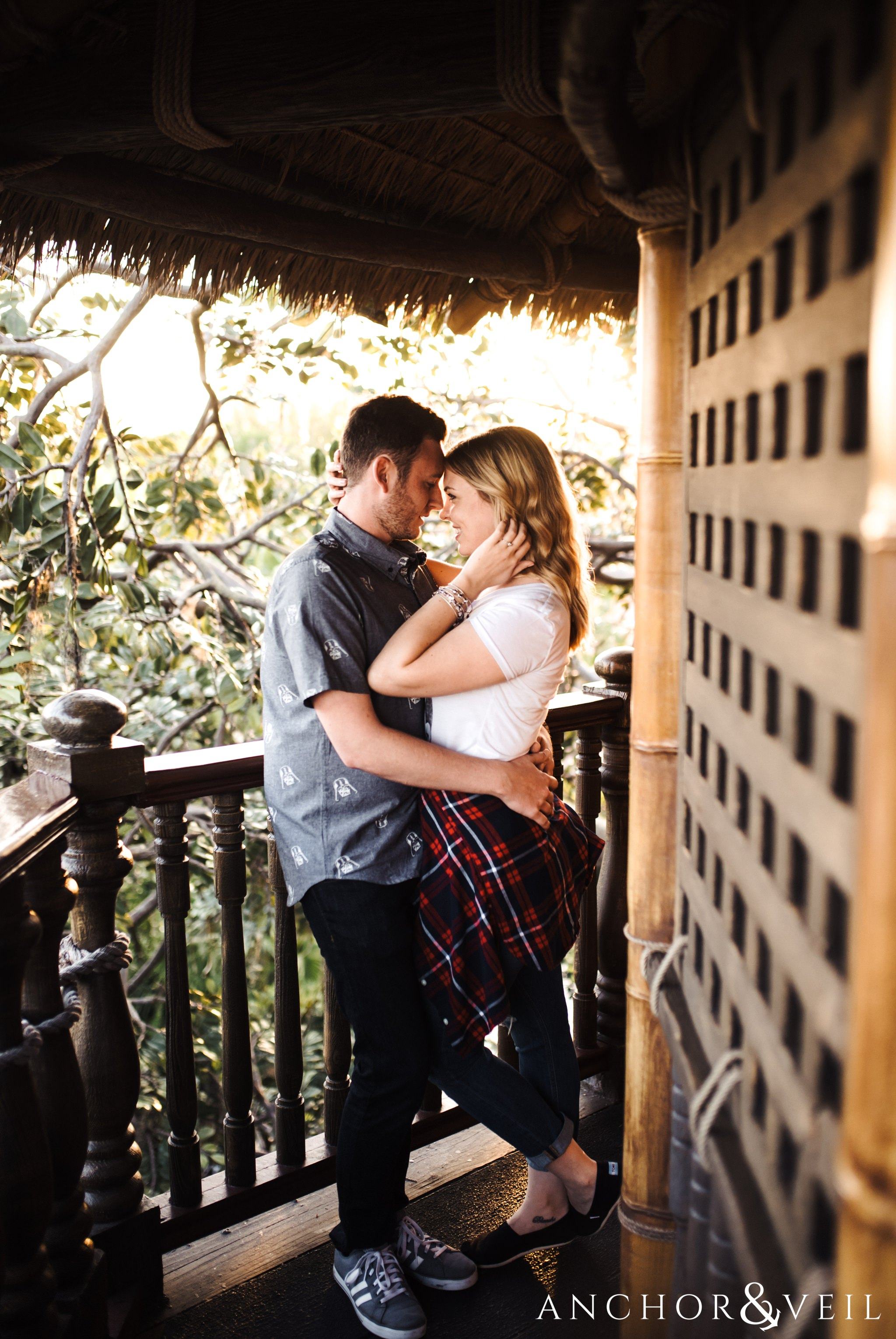moving her hair in the robinson crusoe tree house during their Disney world engagement session at Disney's Magic Kingdom