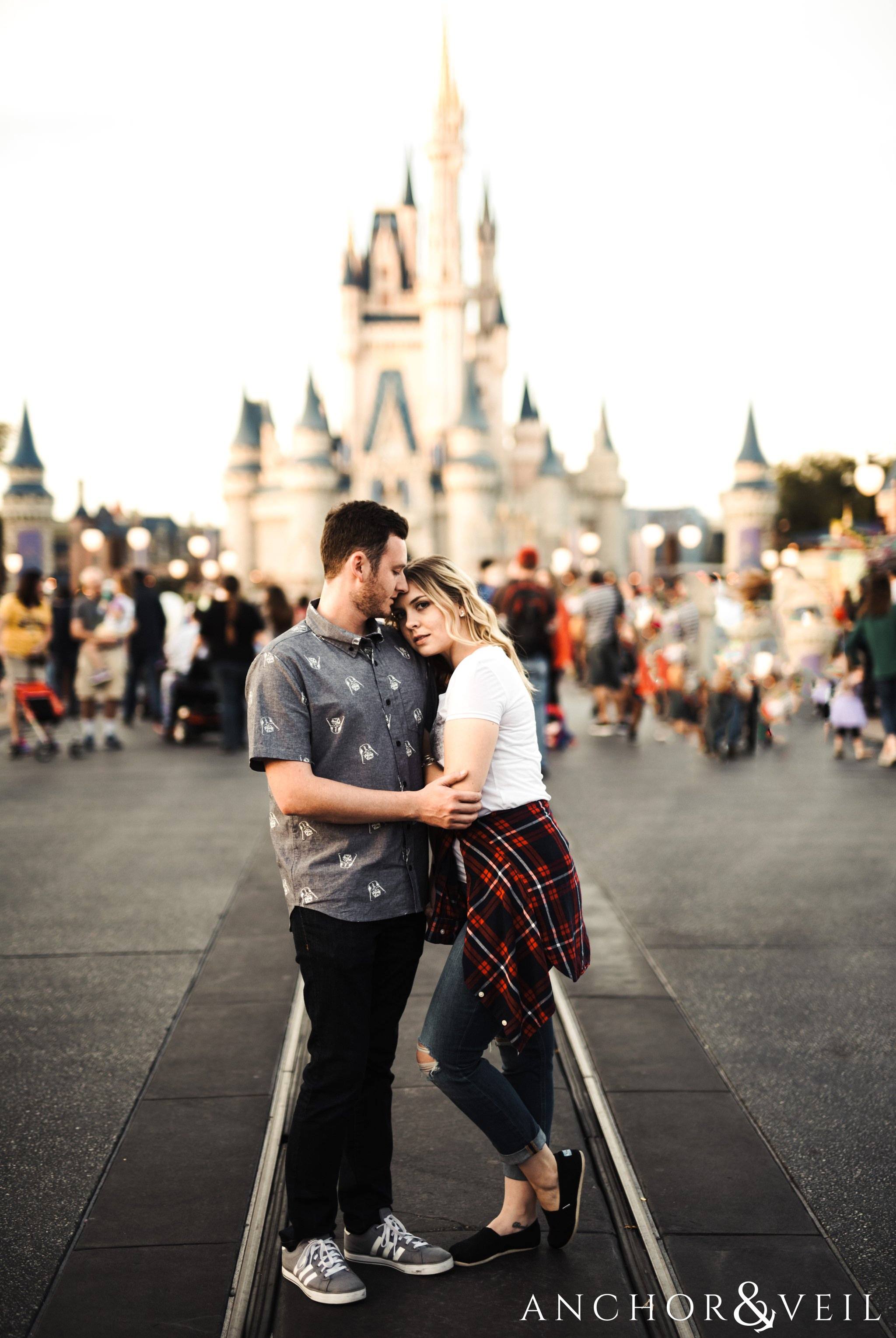 in front of Cinderella's castle during their Disney world engagement session at Disney's Magic Kingdom