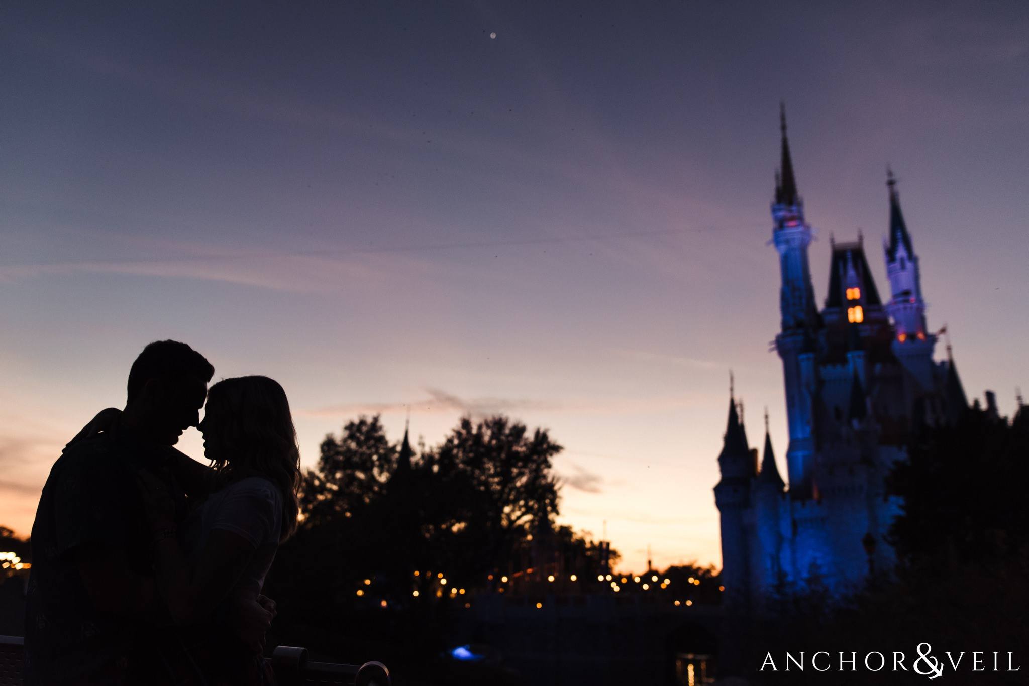 Purple Silhouette in front of Cinderella's castle during their Disney world engagement session at Disney's Magic Kingdom