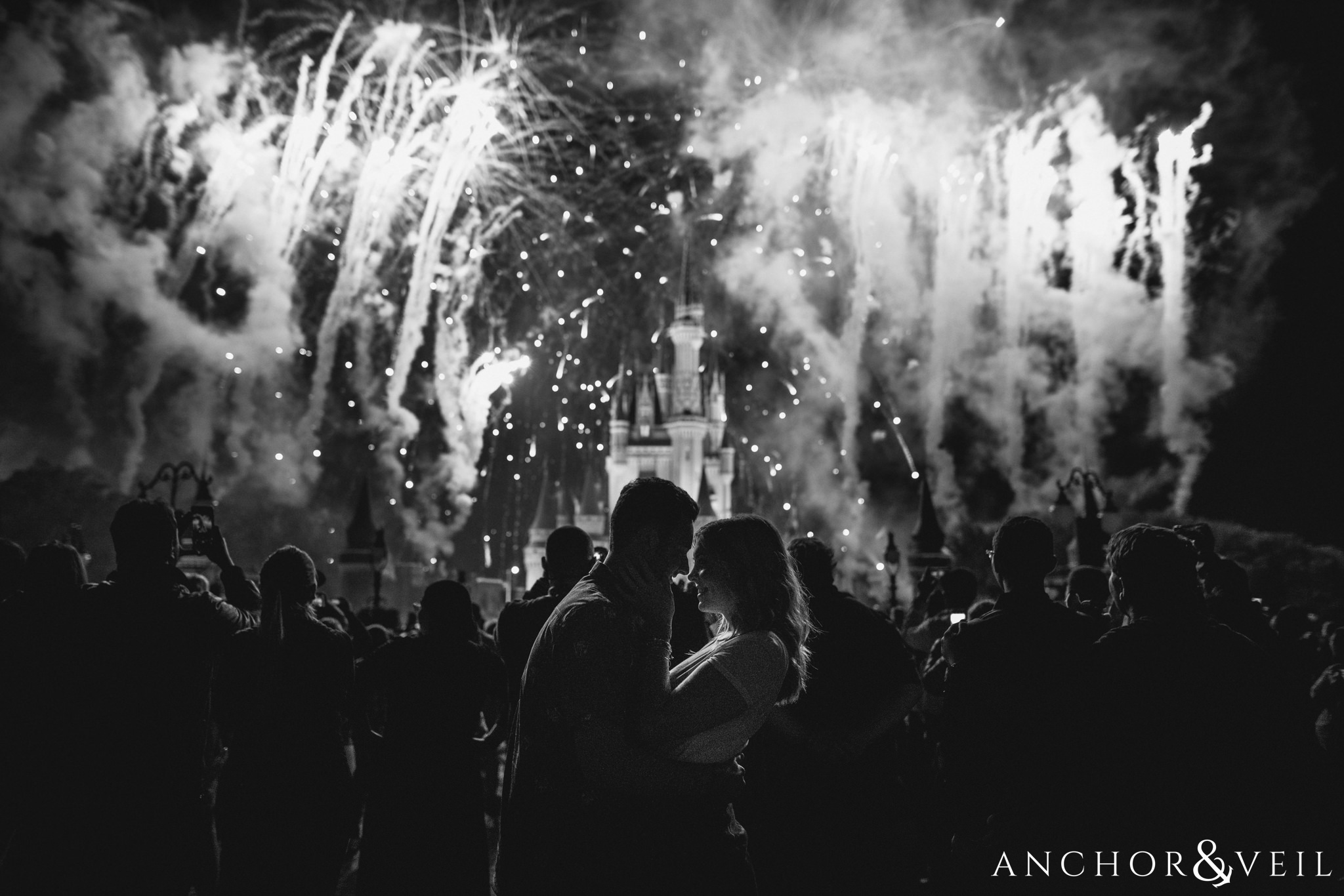 black and white Disney fireworks during their Disney world engagement session at Disney's Magic Kingdom