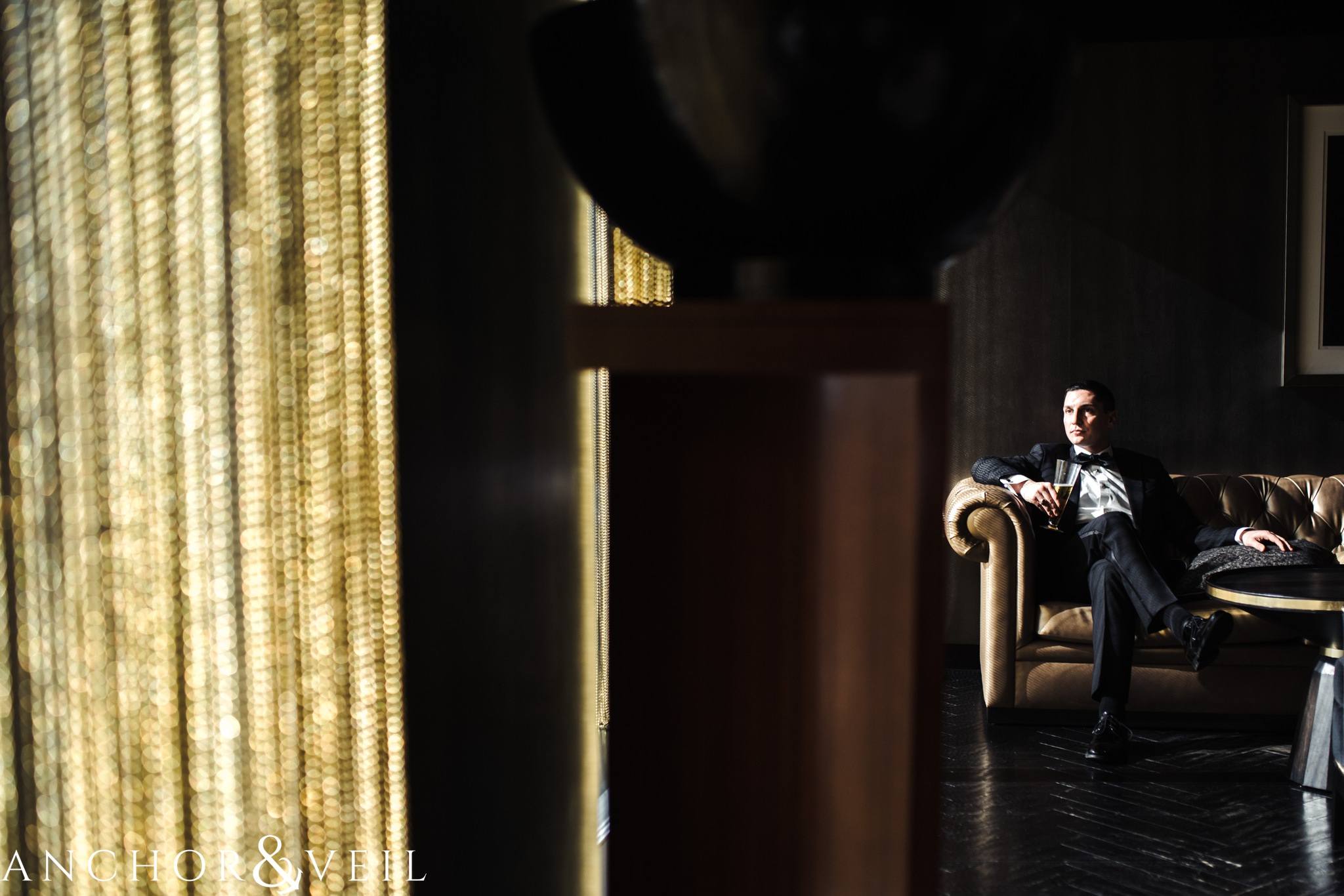 groom hanging out in the punch room during their ritz Carlton wedding in Uptown Charlotte NC