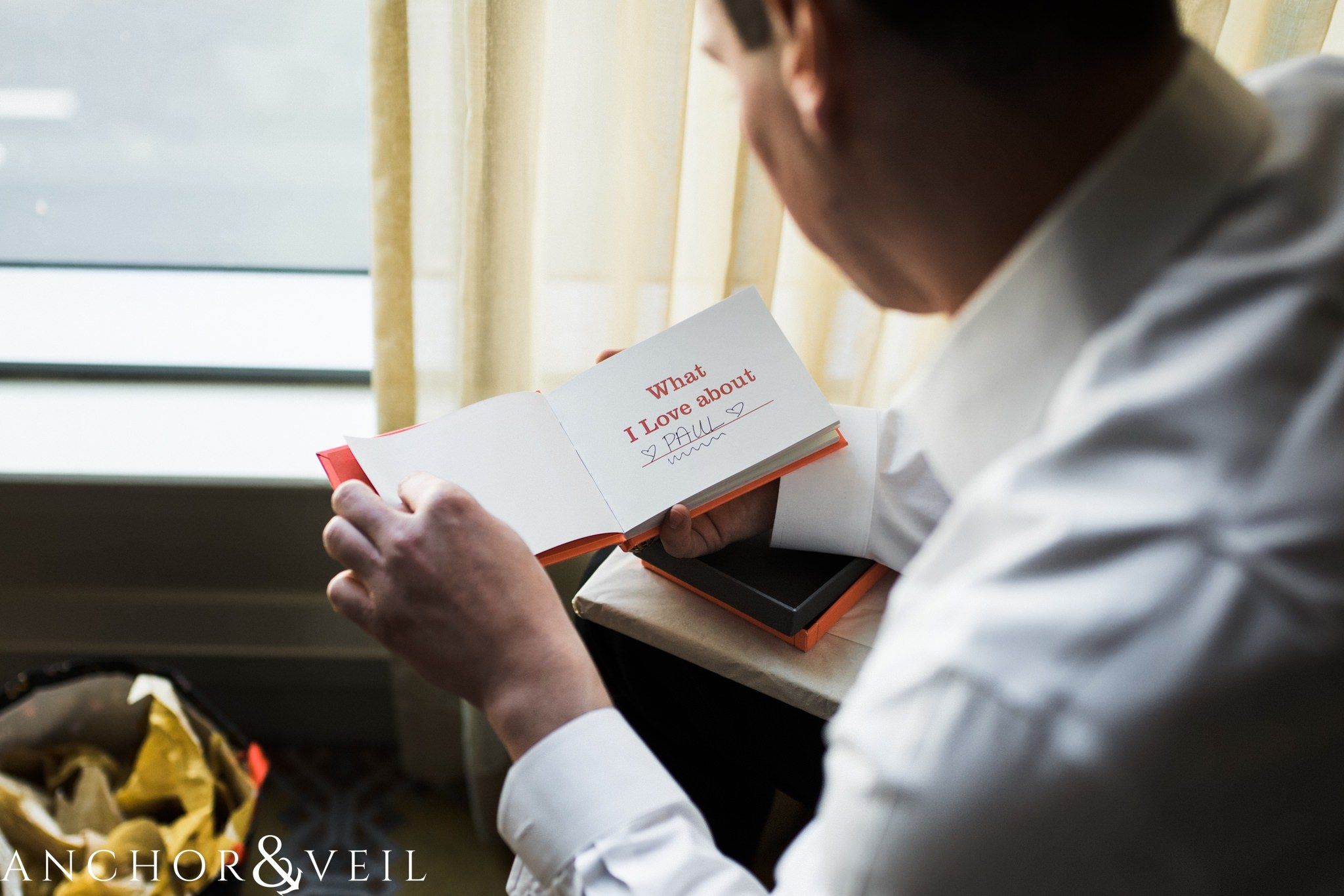 groom reading the book during their ritz Carlton wedding in Uptown Charlotte NC