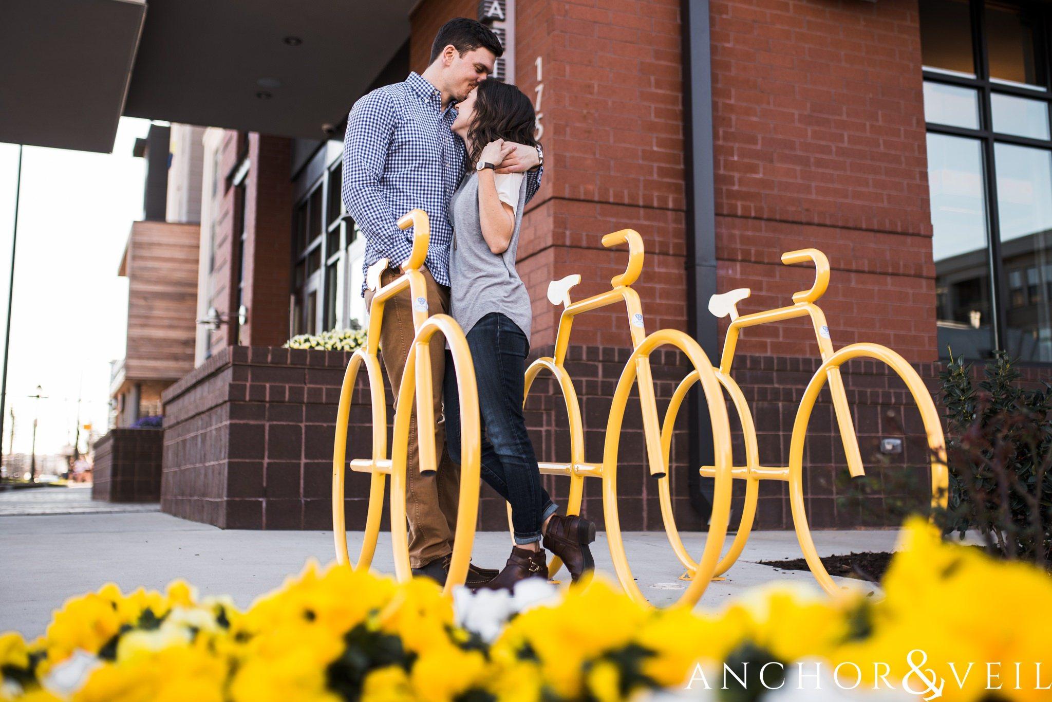 next to the yellow bikes during their southend Charlotte and Jetton park engagement session