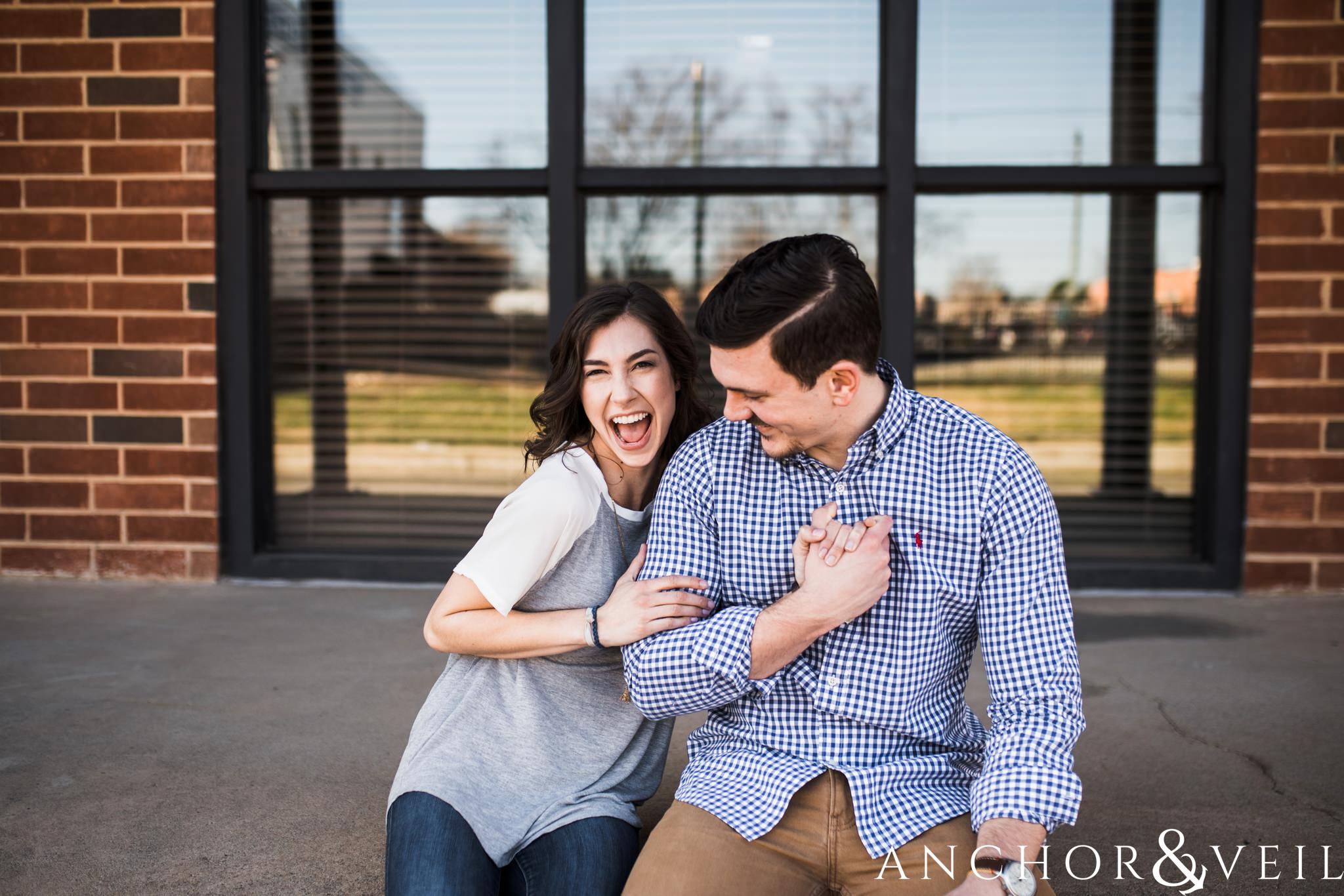 squeezing his biceps during their southend Charlotte and Jetton park engagement session