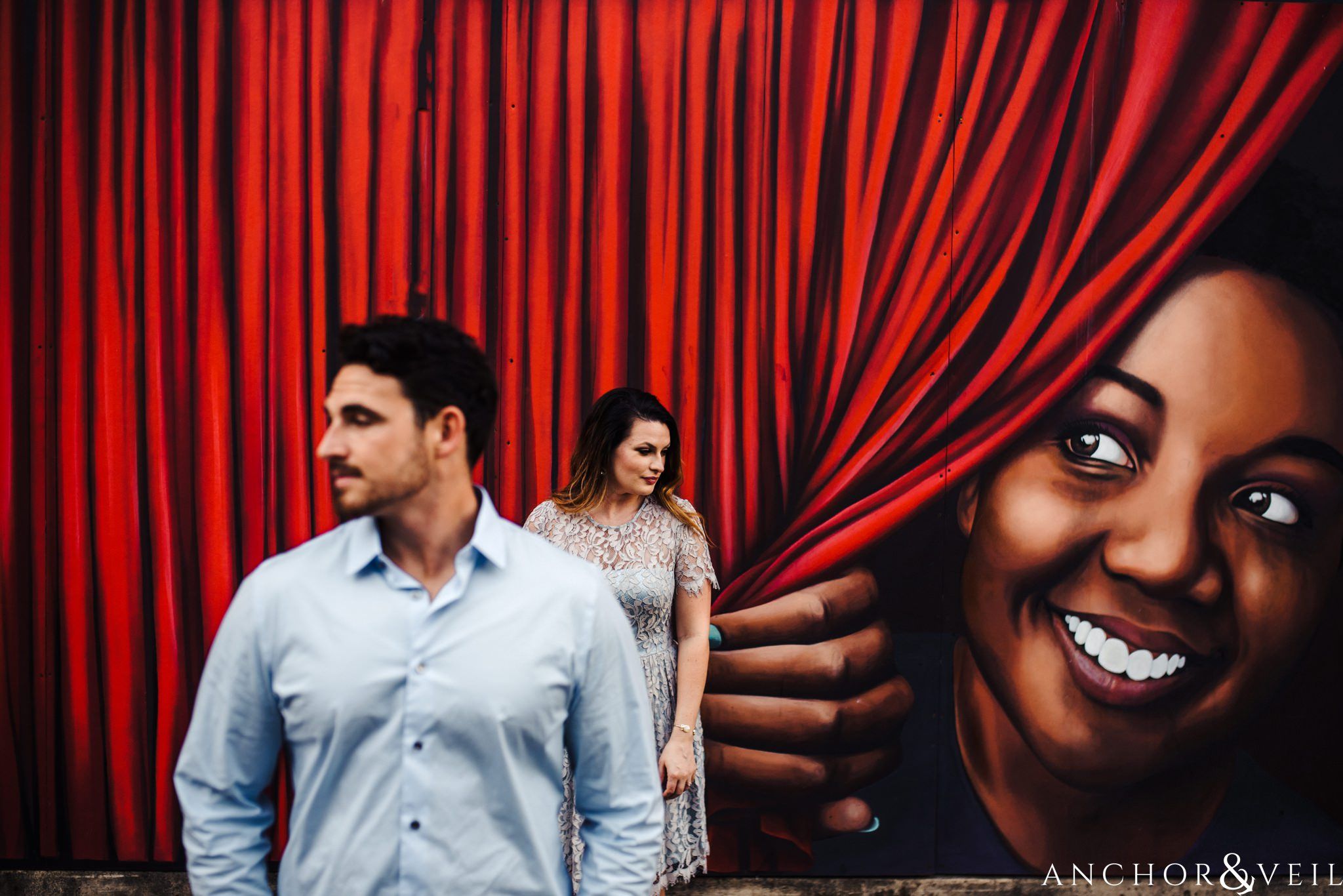 peeking behind the curtain during their Uptown Charlotte NC Engagement Session