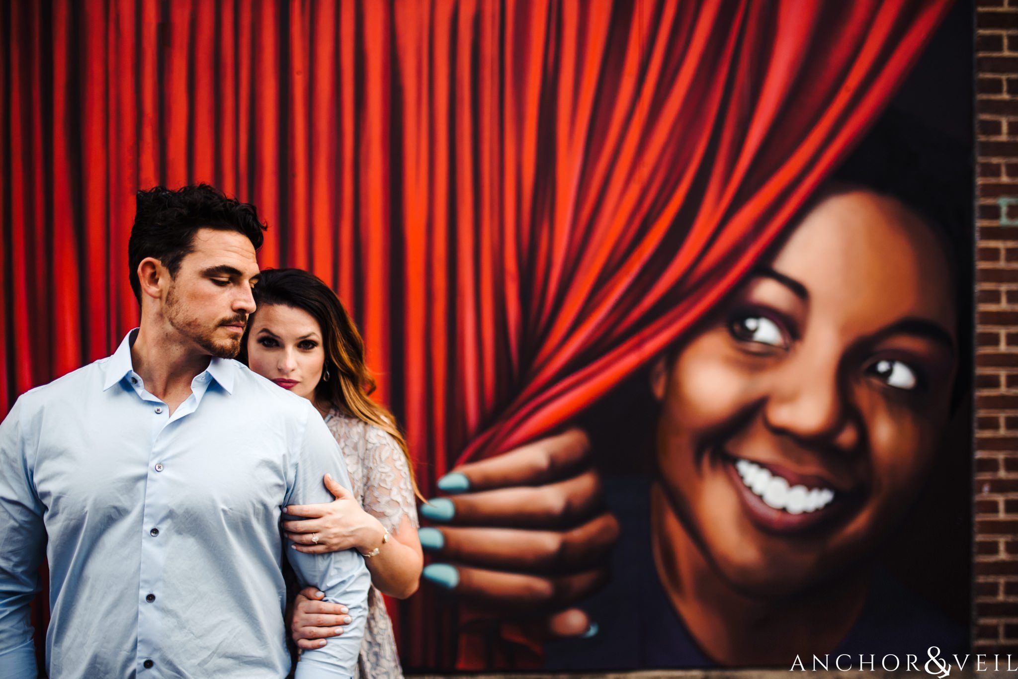 peeking behind the curtain paining during their Uptown Charlotte NC Engagement Session