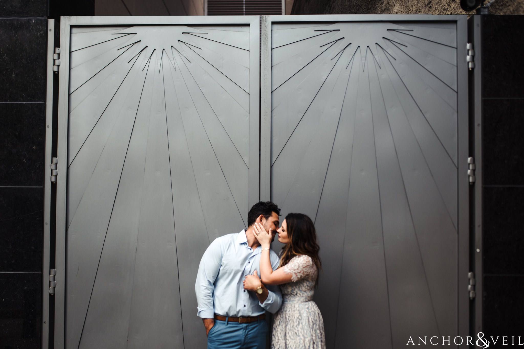 standing agains the silver wall during their Uptown Charlotte NC Engagement Session