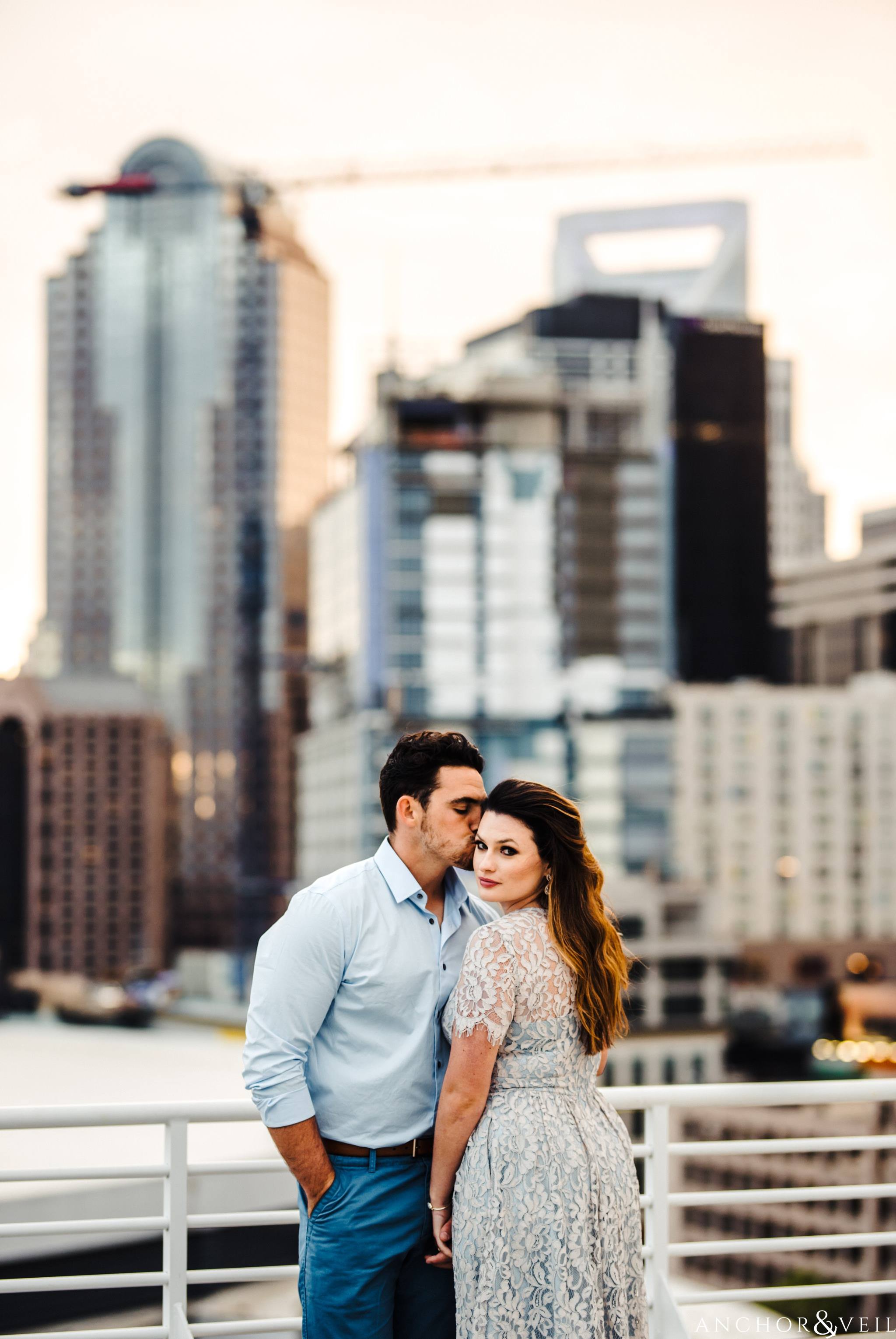 uptown skyline during their Uptown Charlotte NC Engagement Session