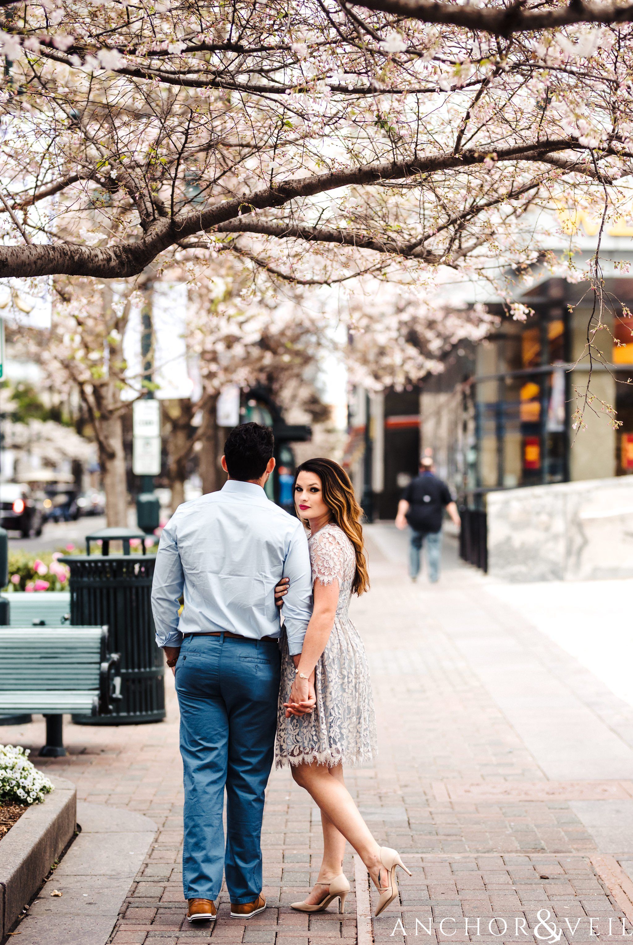 under the blossom tree during their Uptown Charlotte NC Engagement Session
