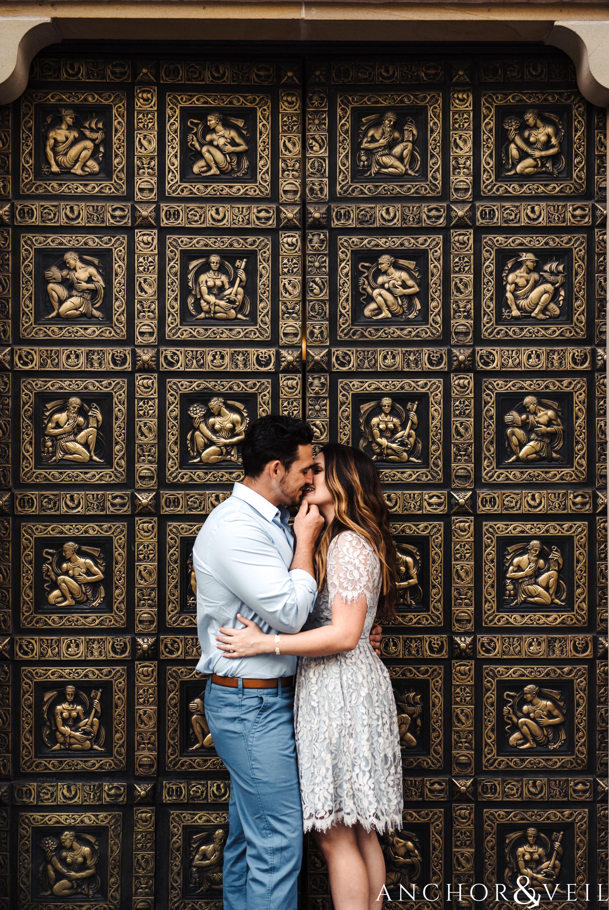 kissing in front of the gold door during their Uptown Charlotte NC Engagement Session