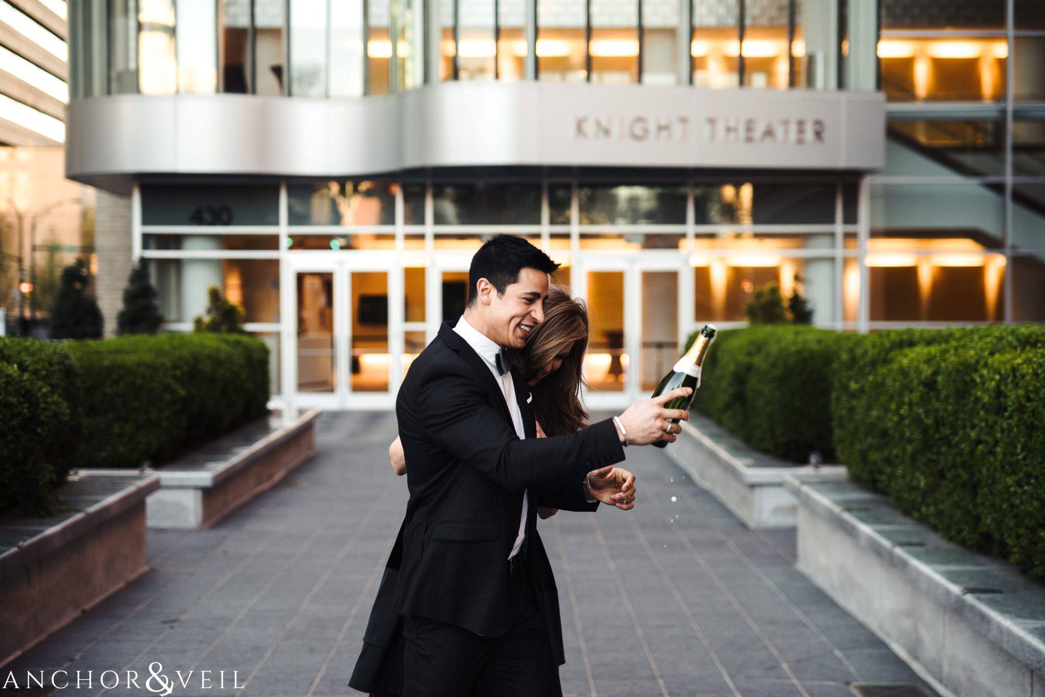 Champaign in from of the Knight Theatre During their Uptown Charlotte Engagement Session