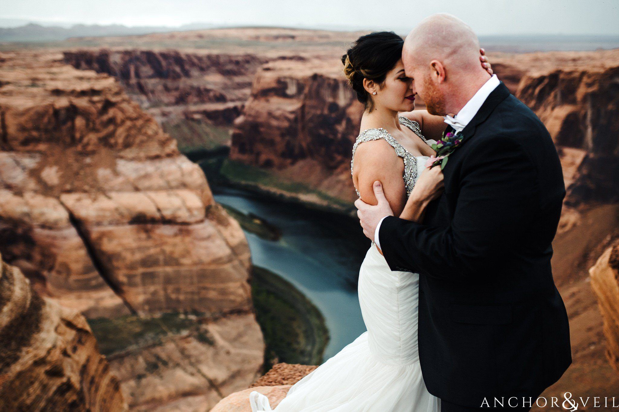 bringing him close on the edge during their Horseshoe Bend Elopement Wedding